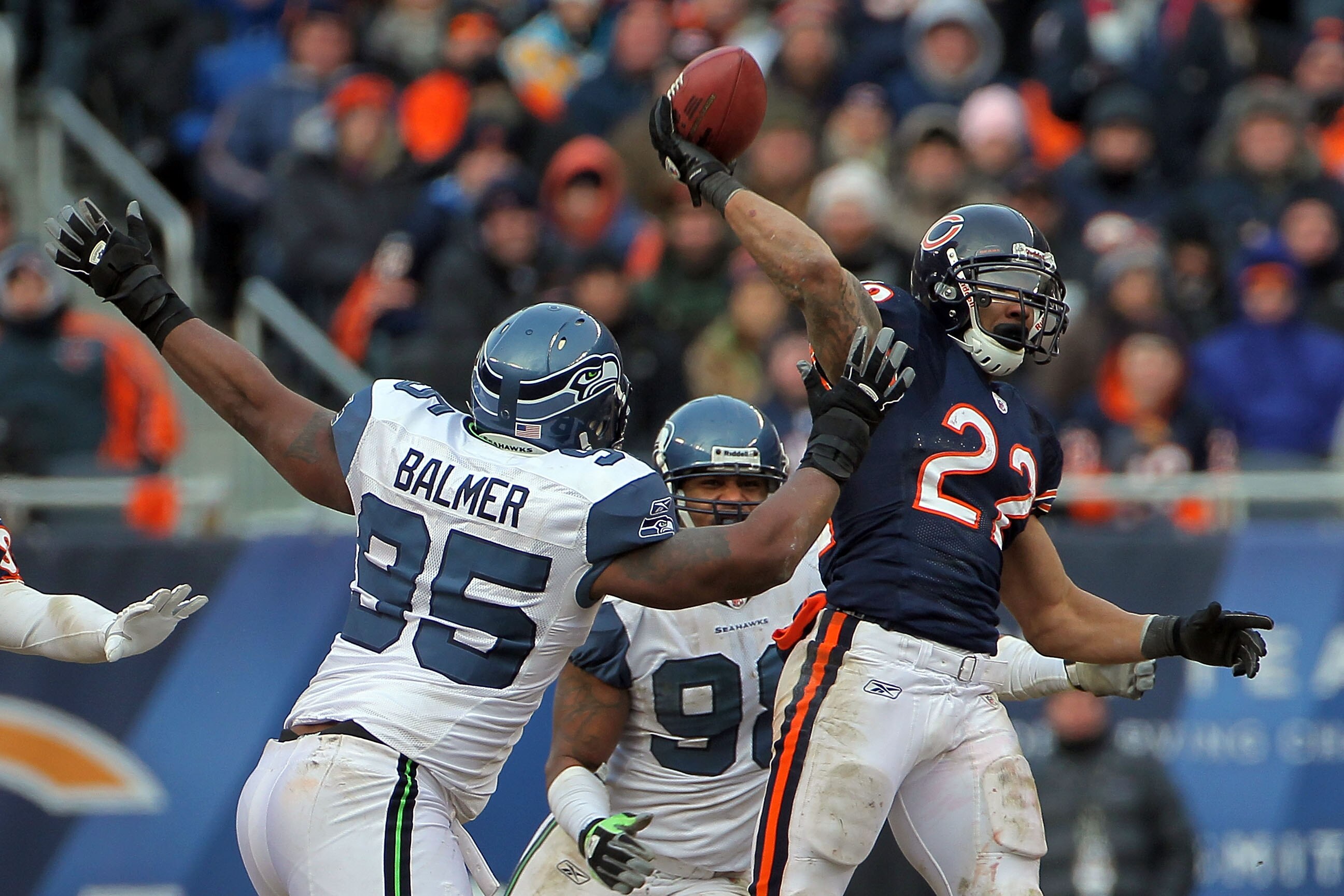 CHICAGO, IL - JANUARY 16:  Running back Matt Forte #22 of the Chicago Bears throws a pass over the arm of Kentwan Balmer #95 of the Seattle Seahawks as the pass is intercepted by Aaron Curry #59 in the second half of the 2011 NFC divisional playoff game a