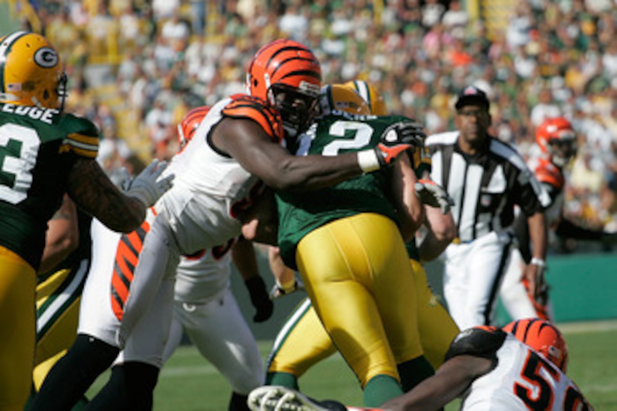 GREEN BAY, WI - SEPTEMBER 20: Quarterback Aaron Rogers #12 of the Green Bay Packers is sacked by defensive end Antwan Odem #98 of the Cincinnati Bengals at Lambeau Field on September 20, 2009 in Green Bay, Wisconsin. The Bengals defeated the Packers 31-24