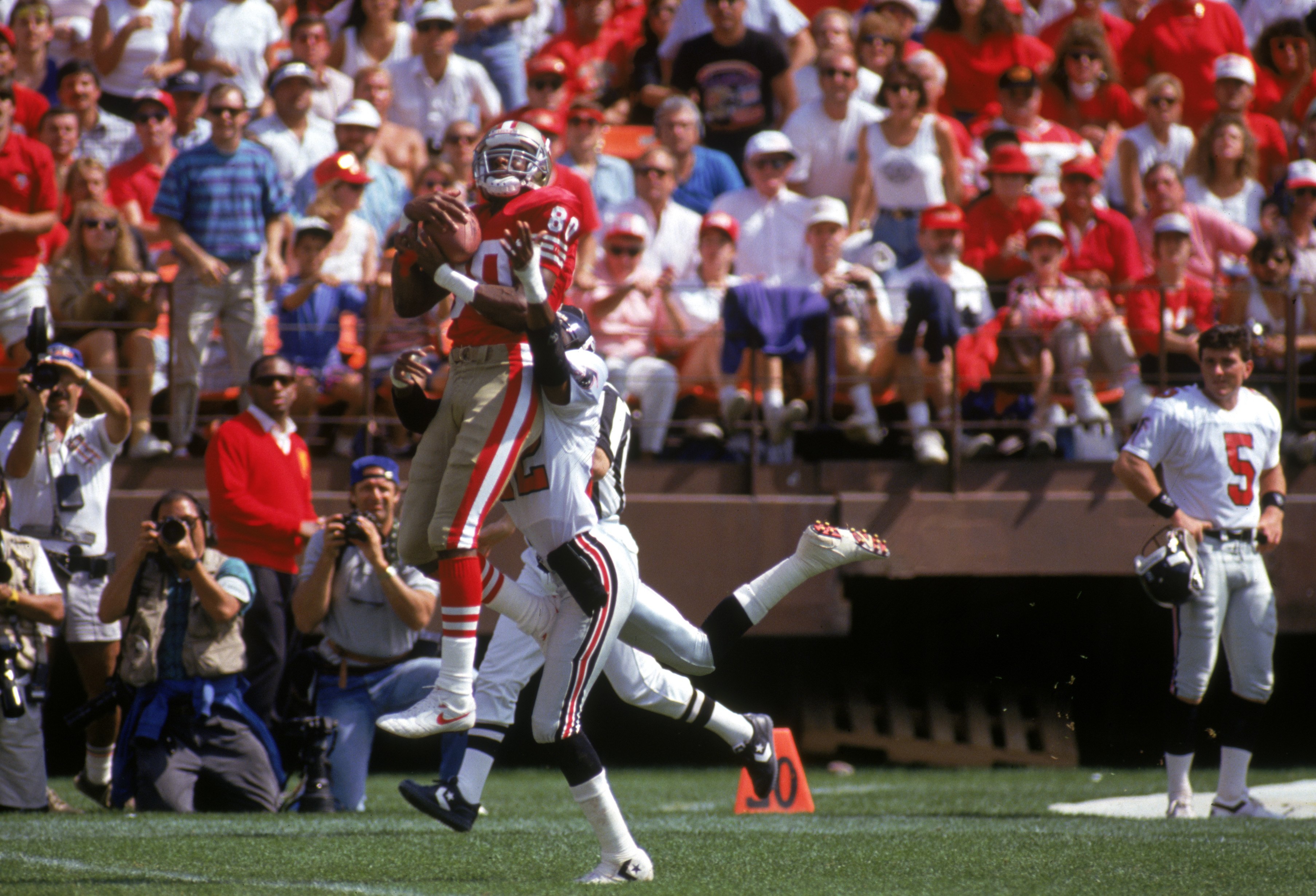 SAN FRANCISCO - SEPTEMBER 23:  Wide receiver Jerry Rice #80 of the San Francisco 49ers goes up over Atlanta Falcons cornerback Charles Dimry #22 during a game at Candlestick Park on September 23, 1990 in San Francisco, California.  The 49ers won 19-13.  (
