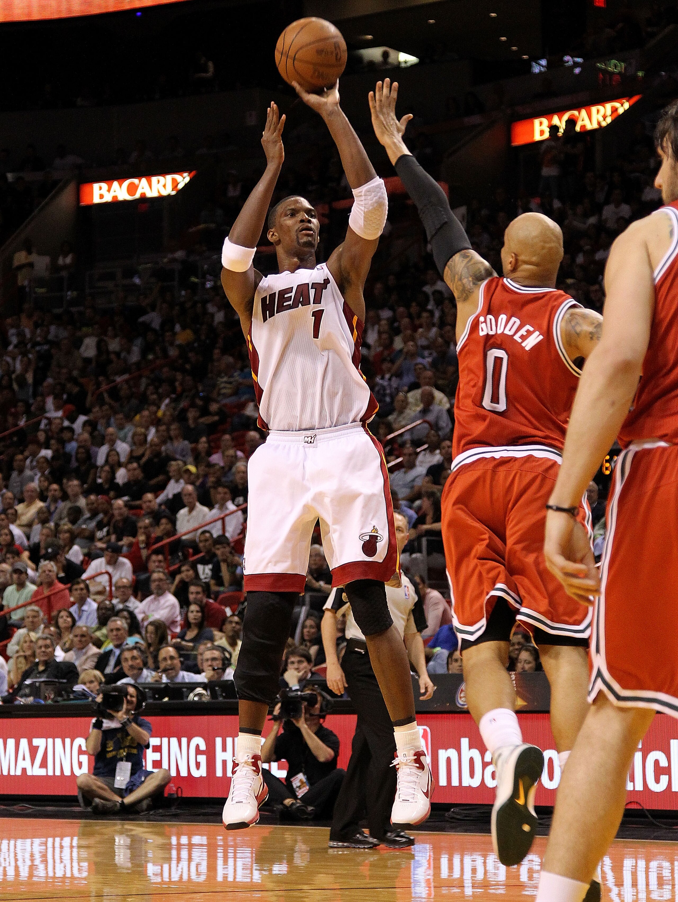 MIAMI, FL - APRIL 06:  Chris Bosh #1 of the Miami Heat shoots a jump shot over Drew Gooden #0 of the Milwaukee Bucks during a game against at American Airlines Arena on April 6, 2011 in Miami, Florida. NOTE TO USER: User expressly acknowledges and agrees