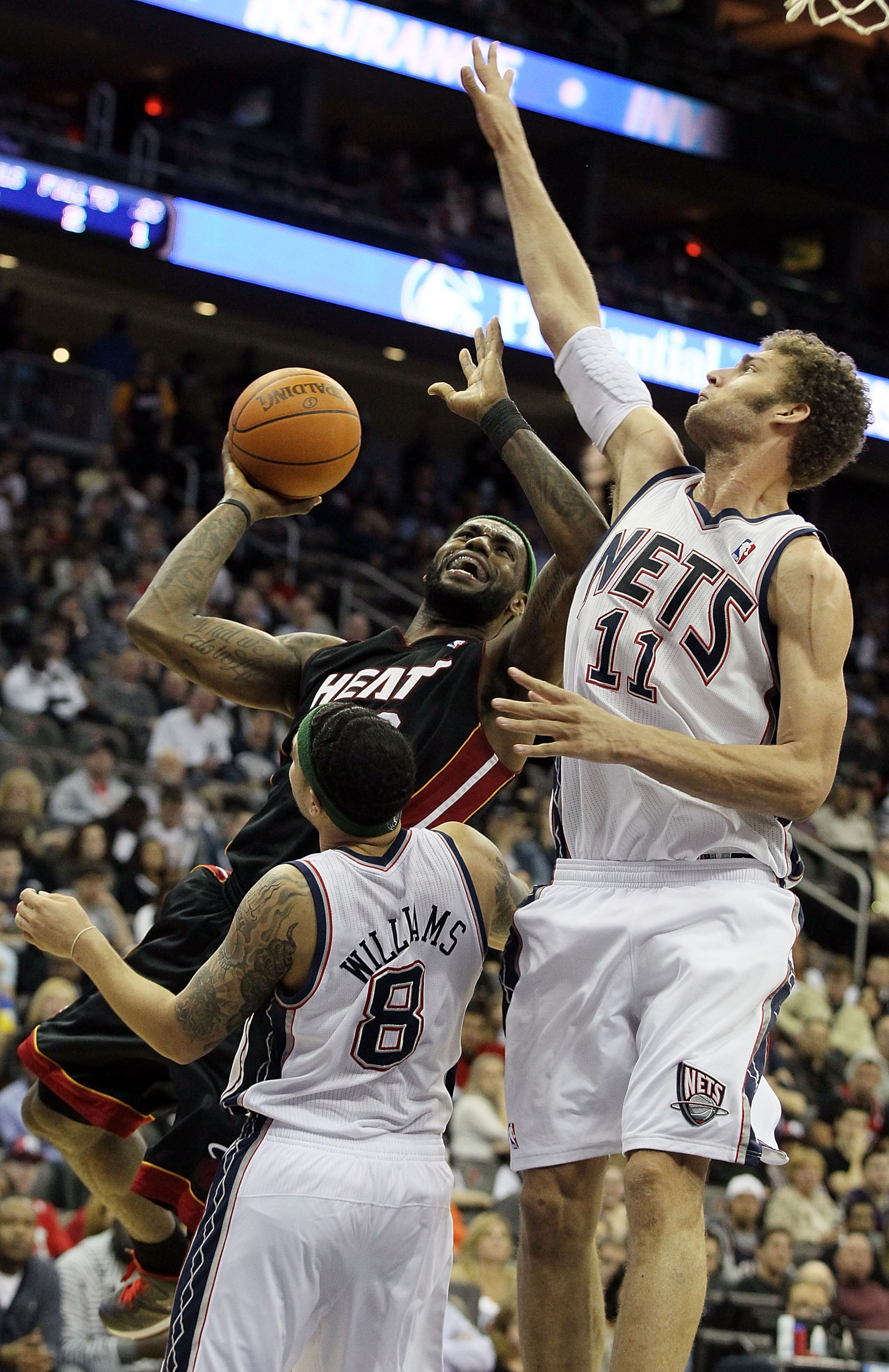 NEWARK, NJ - APRIL 03:  LeBron James #6 of the Miami Heat goes to the hoop against Brook Lopez #11 and Deron Williams #8 of the New Jersey Nets at the Prudential Center on April 3, 2011 in Newark, New Jersey.The Heat defeated the Nets 108-94.NOTE TO USER: