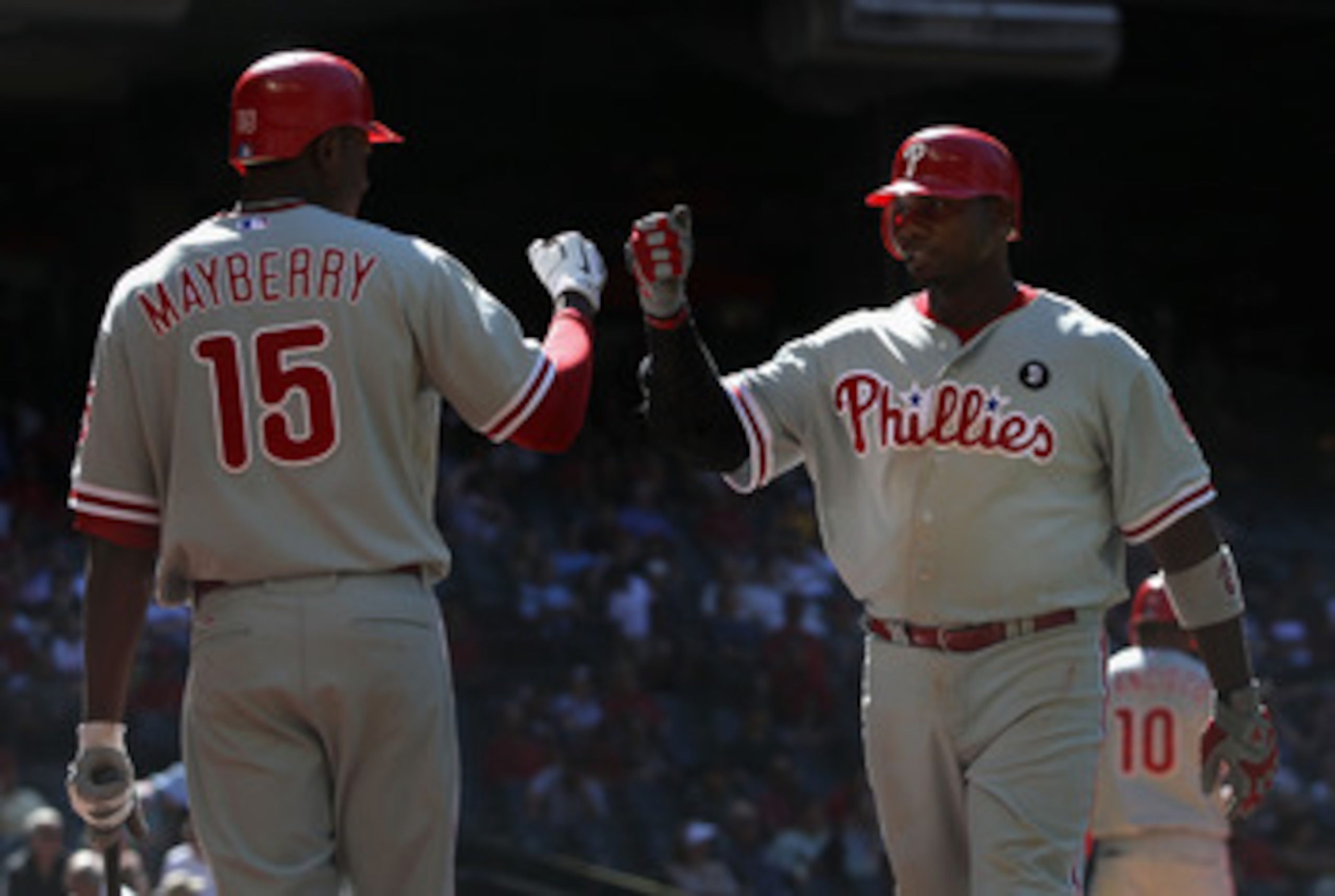 PHOENIX, AZ - APRIL 27:  Ryan Howard #6 of the Philadelphia Phillies high fives teammate John Mayberry #15 after scoring against the Arizona Diamondbacks during the Major League Baseball game at Chase Field on April 27, 2011 in Phoenix, Arizona.  The Phil