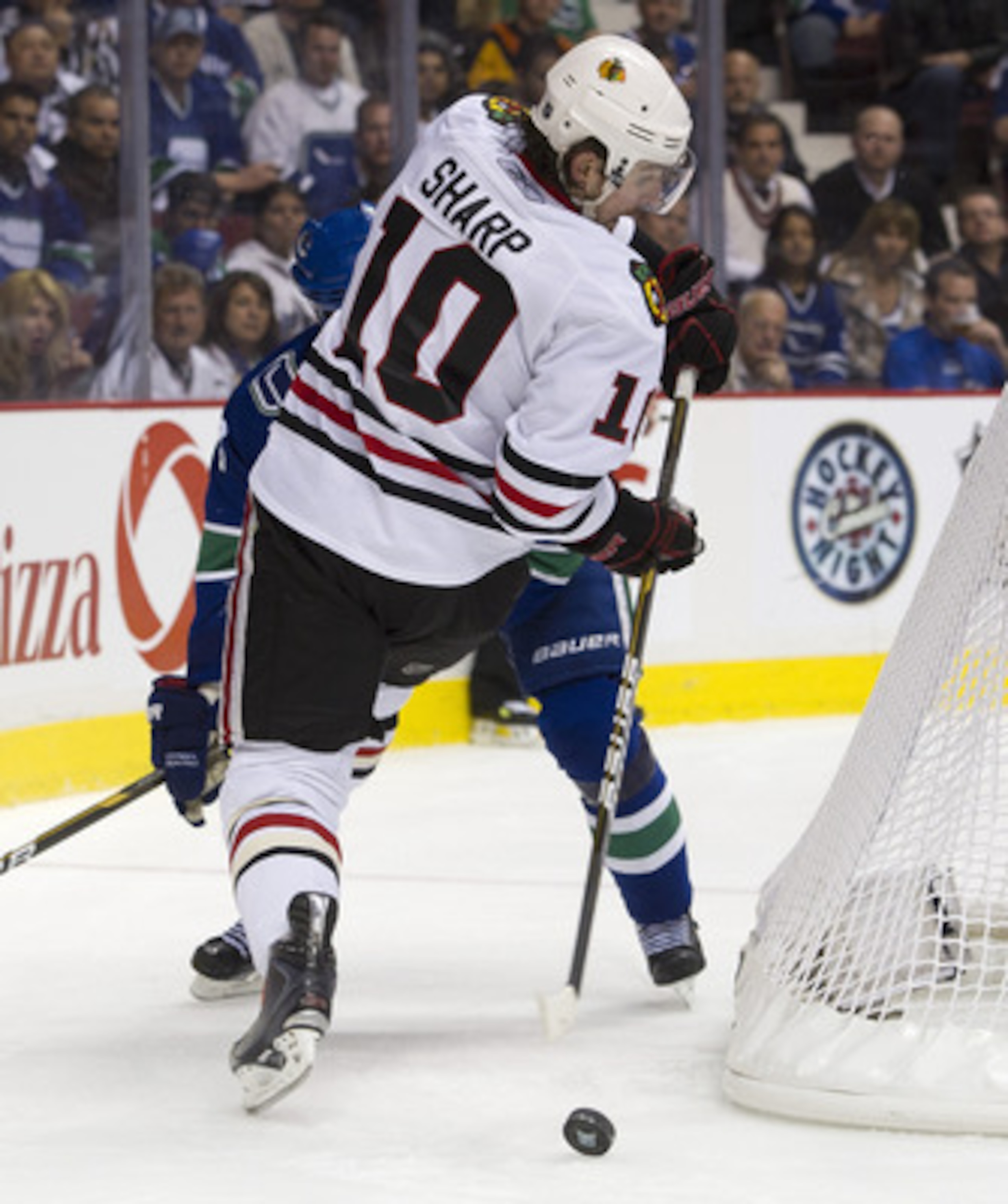 VANCOUVER, CANADA - APRIL 26: Patrick Sharp #10 of the Chicago Blackhawks makes a pass while falling as Kevin Bieksa #3 of the Vancouver Canucks looks on during the second period in Game Seven of the Western Conference Quarterfinals during the 2011 NHL St