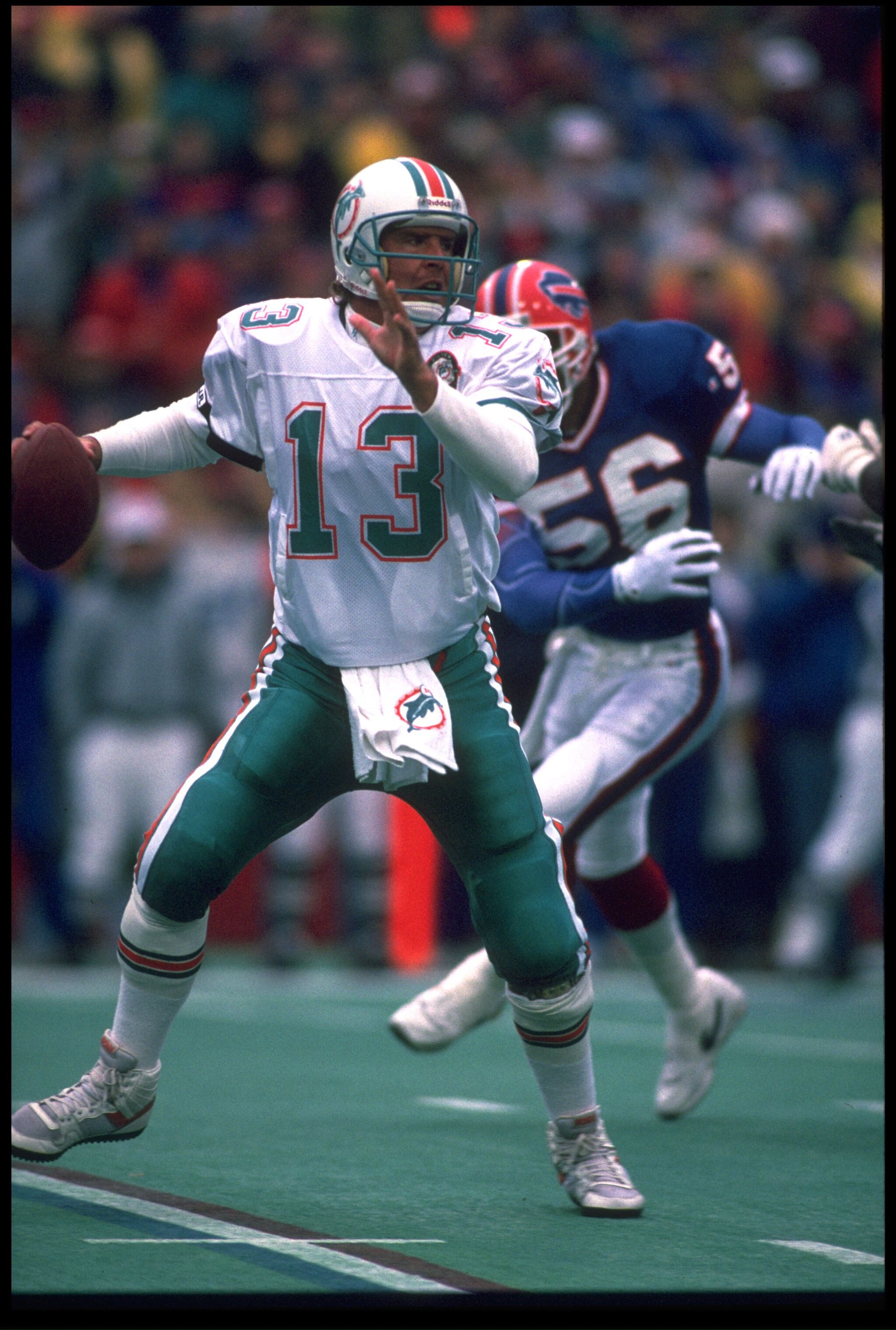 23 DEC 1990:  DAN MARINO #13, QUARTERBACK FOR THE MIAMI DOLPHINS, SCRAMBLES AWAY FROM BUFFALO BILLS LINEBACKER DARRYL TALLEY #56 DURING THE BILLS'' 24-14 WIN AT RICH STADIUM IN ORCHARD PARK, NEW YORK.  MANDATORY CREDIT:  RICK STEWART/ALLSPORT