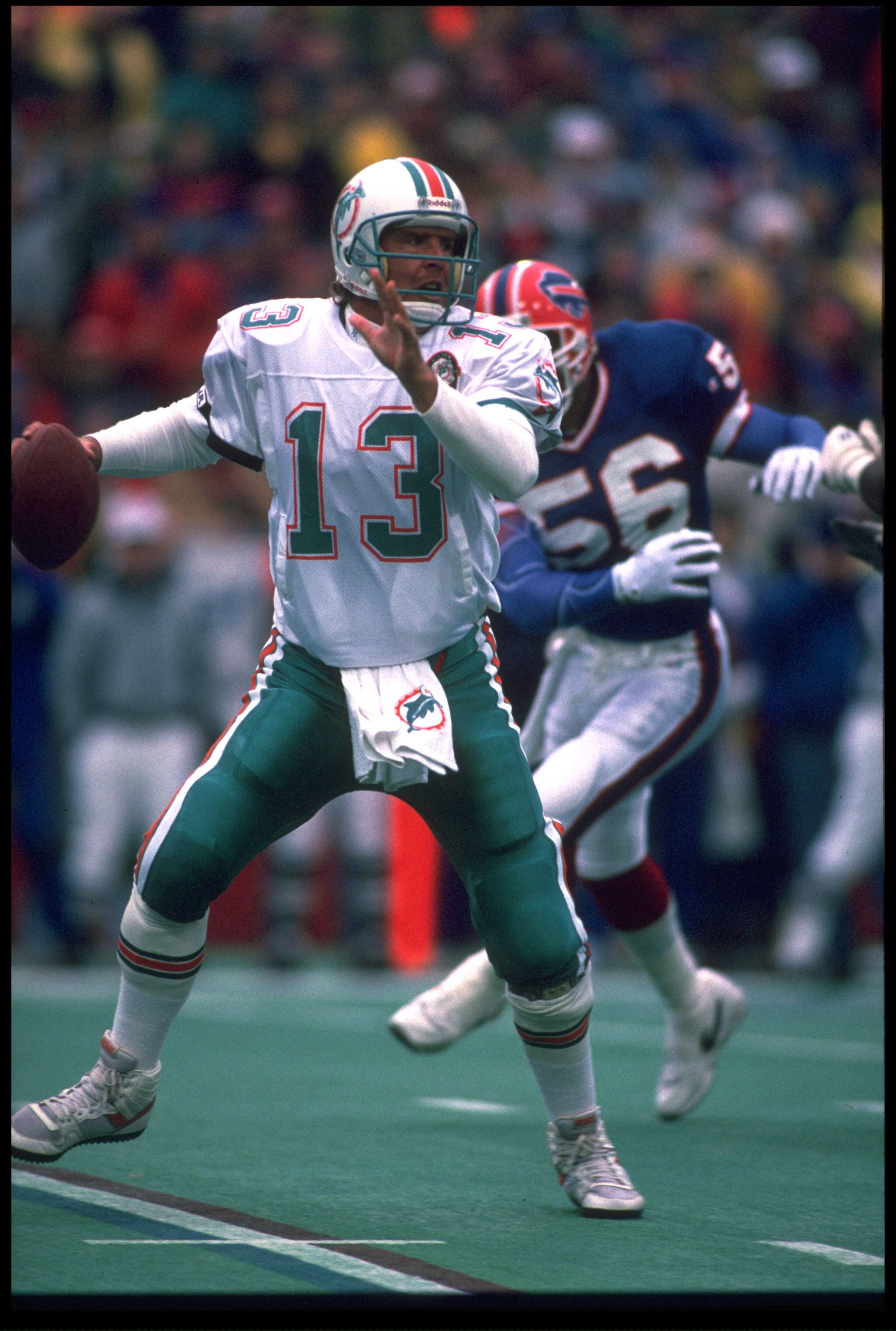 23 DEC 1990:  DAN MARINO #13, QUARTERBACK FOR THE MIAMI DOLPHINS, SCRAMBLES AWAY FROM BUFFALO BILLS LINEBACKER DARRYL TALLEY #56 DURING THE BILLS'' 24-14 WIN AT RICH STADIUM IN ORCHARD PARK, NEW YORK.  MANDATORY CREDIT:  RICK STEWART/ALLSPORT