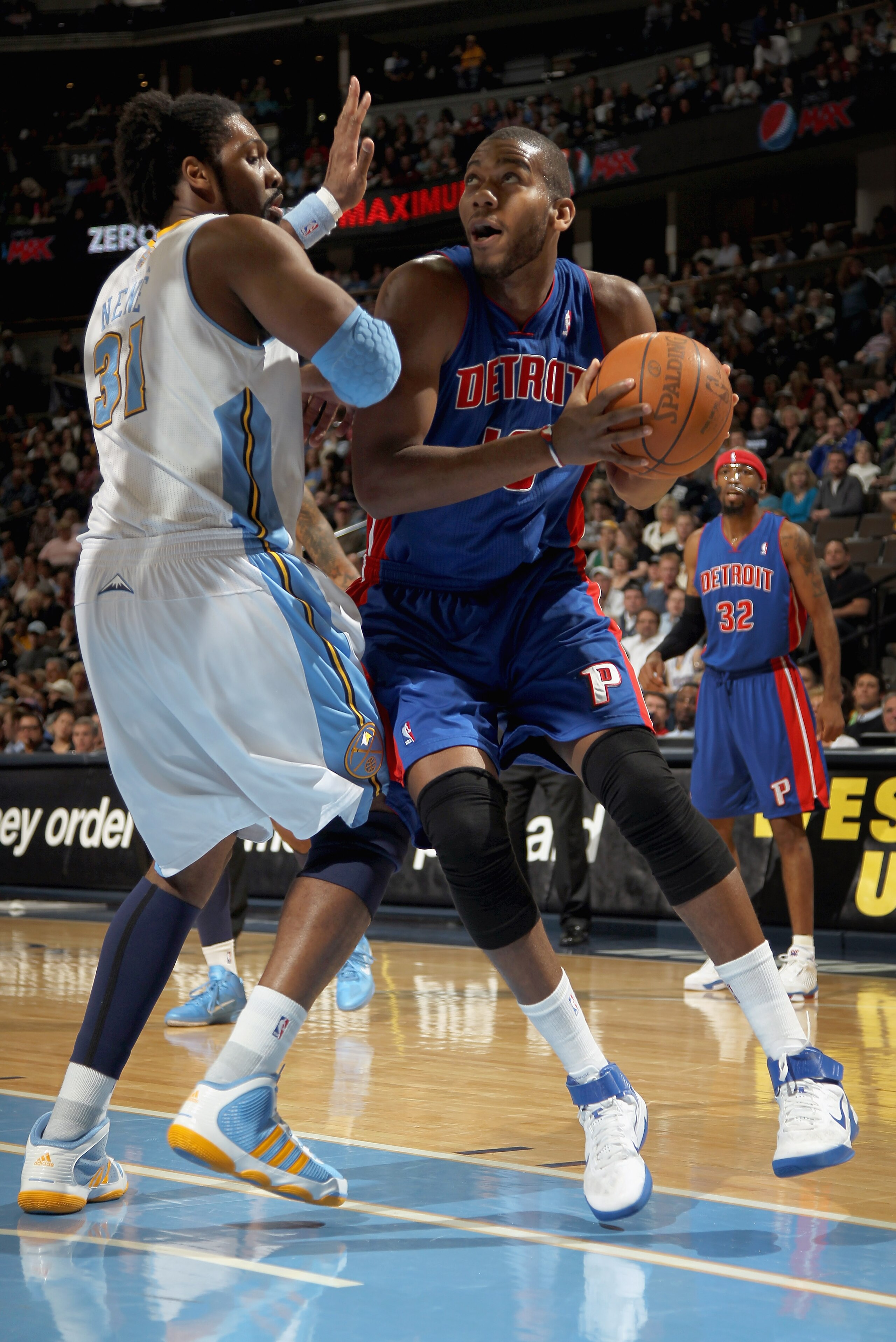DENVER, CO - MARCH 12:  Greg Monroe #10 of the Detroit Pistons goes to the basket against Nene #31 of the Denver Nuggets at the Pepsi Center on March 12, 2011 in Denver, Colorado. The Nuggets defeated the Pistons 131-101.  NOTE TO USER: User expressly ack