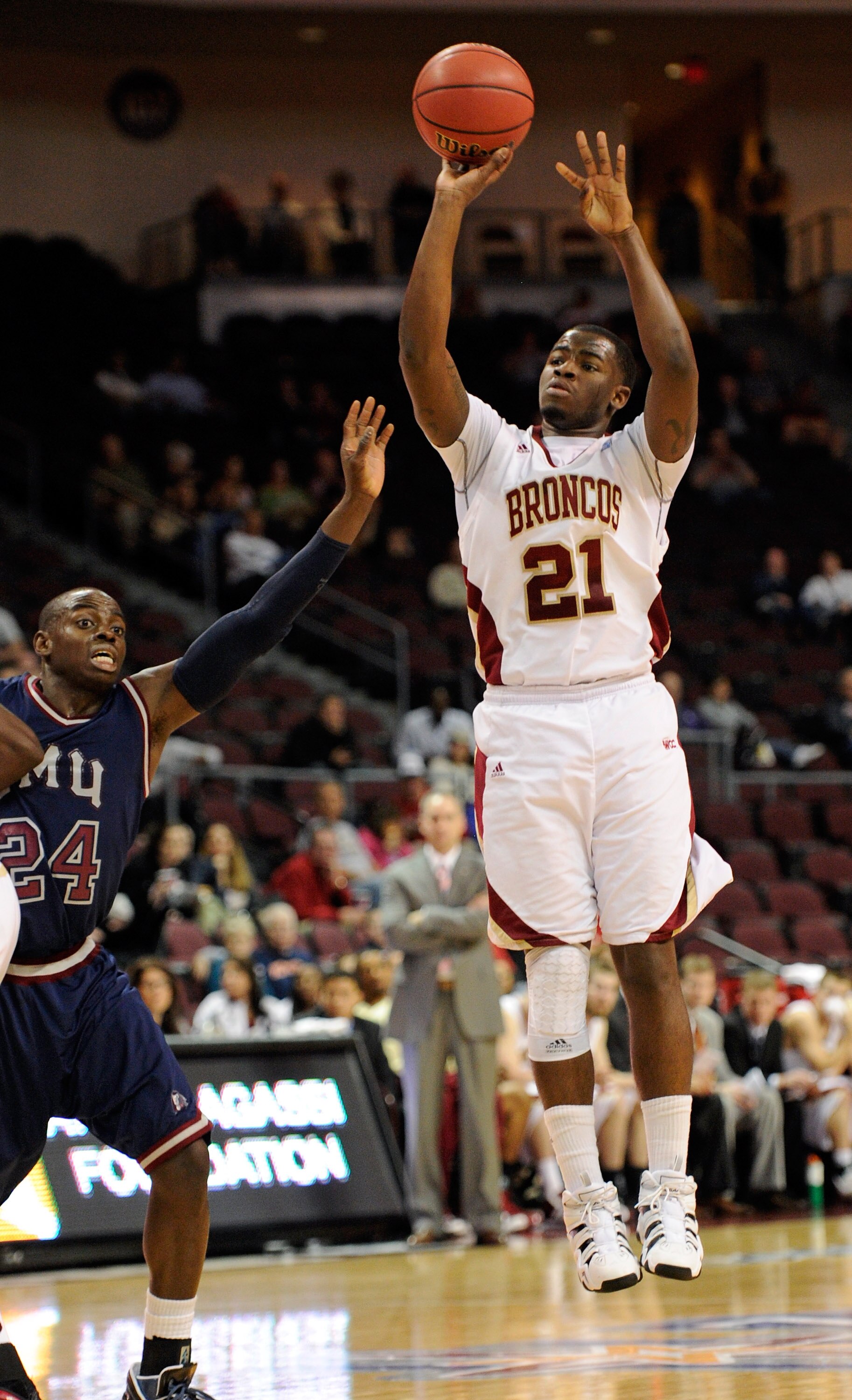 LAS VEGAS, NV - MARCH 05:  Kevin Foster #21 of the Santa Clara Broncos shoots as Ayodeji Egbeyemi #24 of the Loyola Marymount Lions defends during a quarterfinal game of the Zappos.com West Coast Conference Basketball tournament at the Orleans Arena March