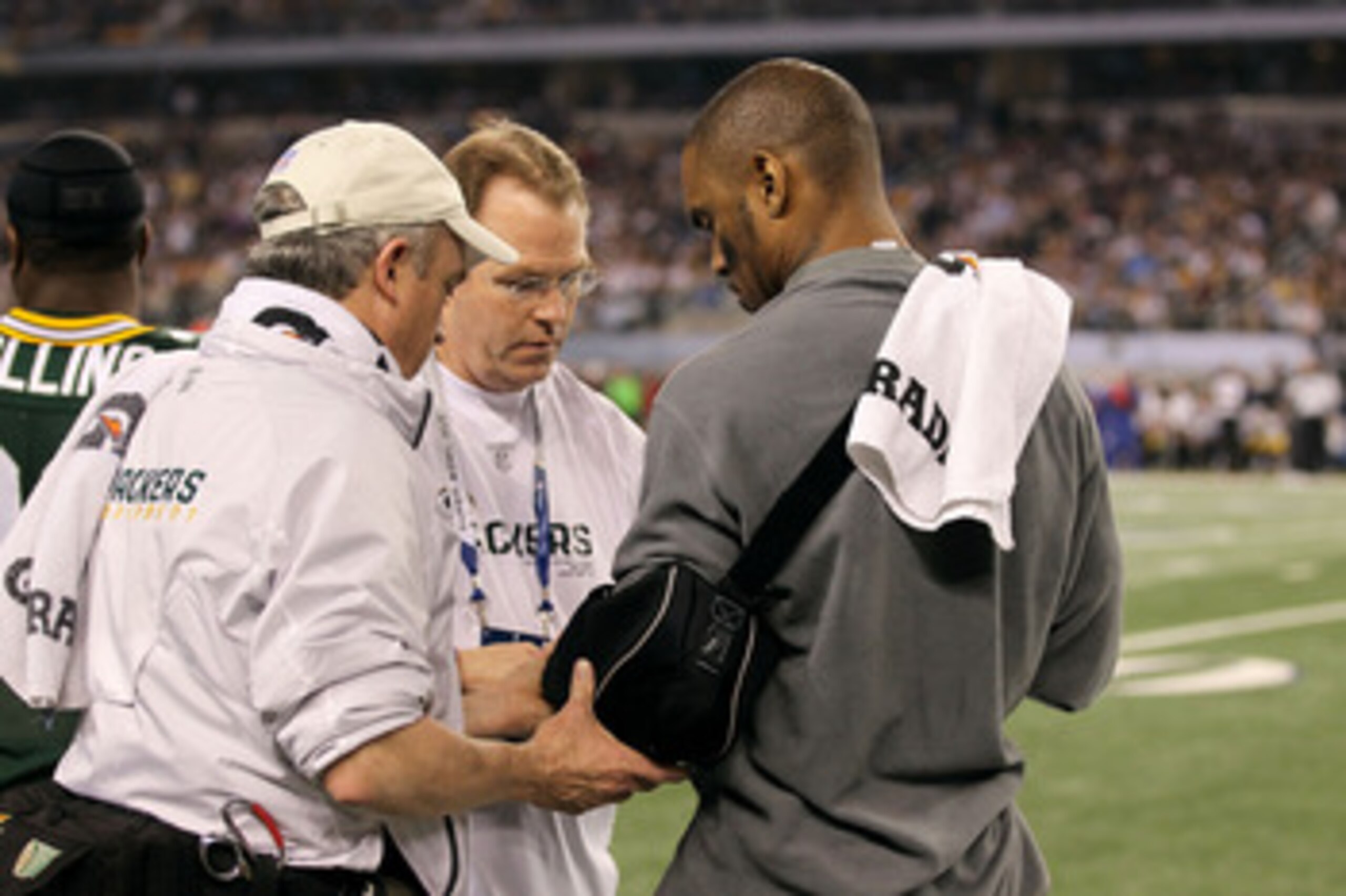 ARLINGTON, TX - FEBRUARY 06:  Charles Woodson #21 of the Green Bay Packers has his injured arm looked at by the Packers' medical staff against the Pittsburgh Steelers during Super Bowl XLV at Cowboys Stadium on February 6, 2011 in Arlington, Texas.  (Phot
