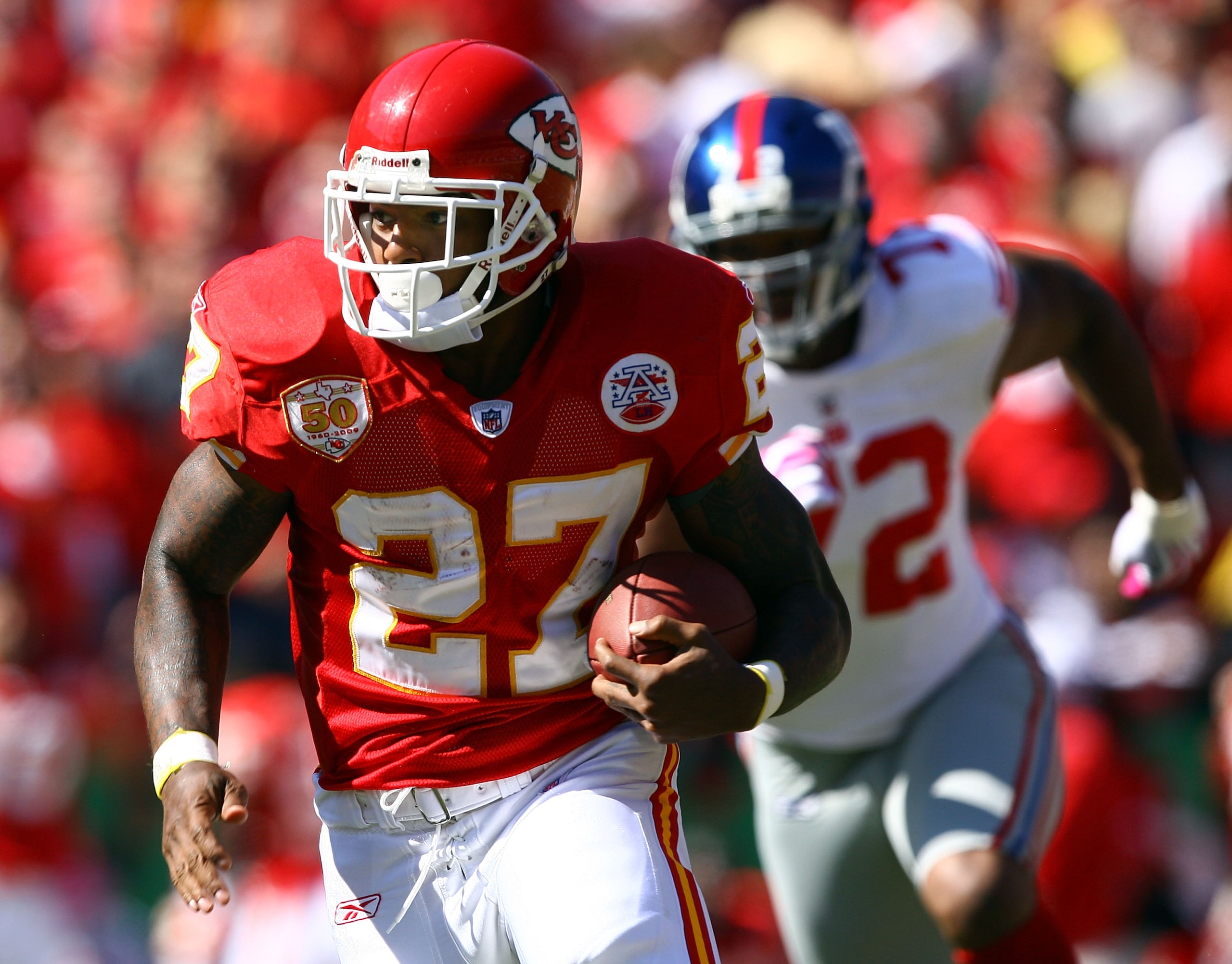 KANSAS CITY, MO - OCTOBER 04:  Running back Larry Johnson #27 of the Kansas City Chiefs carries the ball as Osi Umenyiora #72 of the New York Giants gives chase during the game on October 4, 2009 at Arrowhead Stadium in Kansas City, Missouri.  (Photo by J