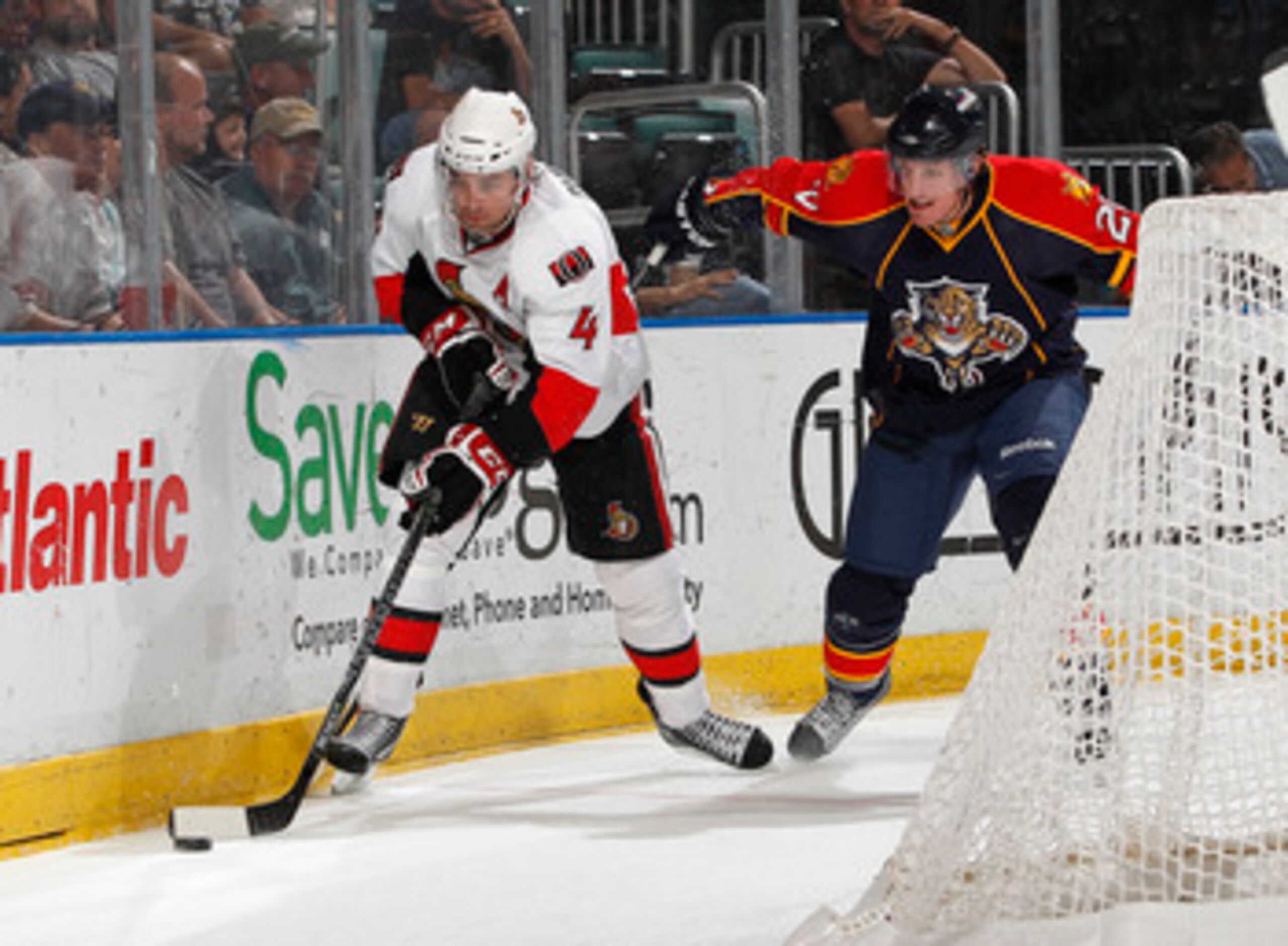 SUNRISE, FL - MARCH 31: Chris Phillips #4 of the Ottawa Senators clears the puck from Ryan Carter #20 of the Florida Panthers on March 31, 2011 at the BankAtlantic Center in Sunrise, Florida. The Senators defeated the Panthers 4-1. (Photo by Joel Auerbach