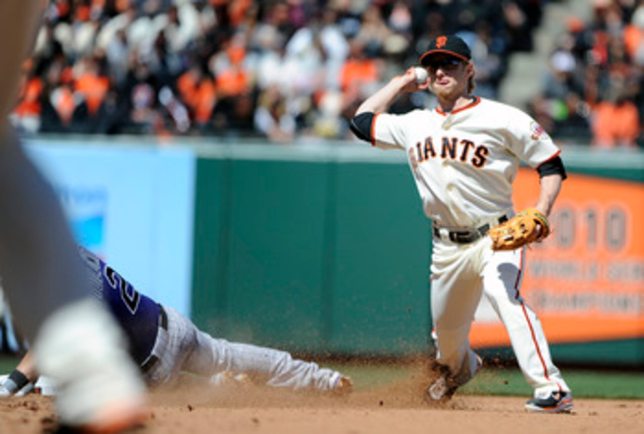 SAN FRANCISCO, CA - MAY 8: Mike Fontenot #14 of the San Francisco Giants gets his throw off to complete the double-play, avoiding the slide of Troy Tulowitzki #2 of the Colorado Rockies during a MLB baseball game at AT&T Park May 8, 2011 in San Francisco,