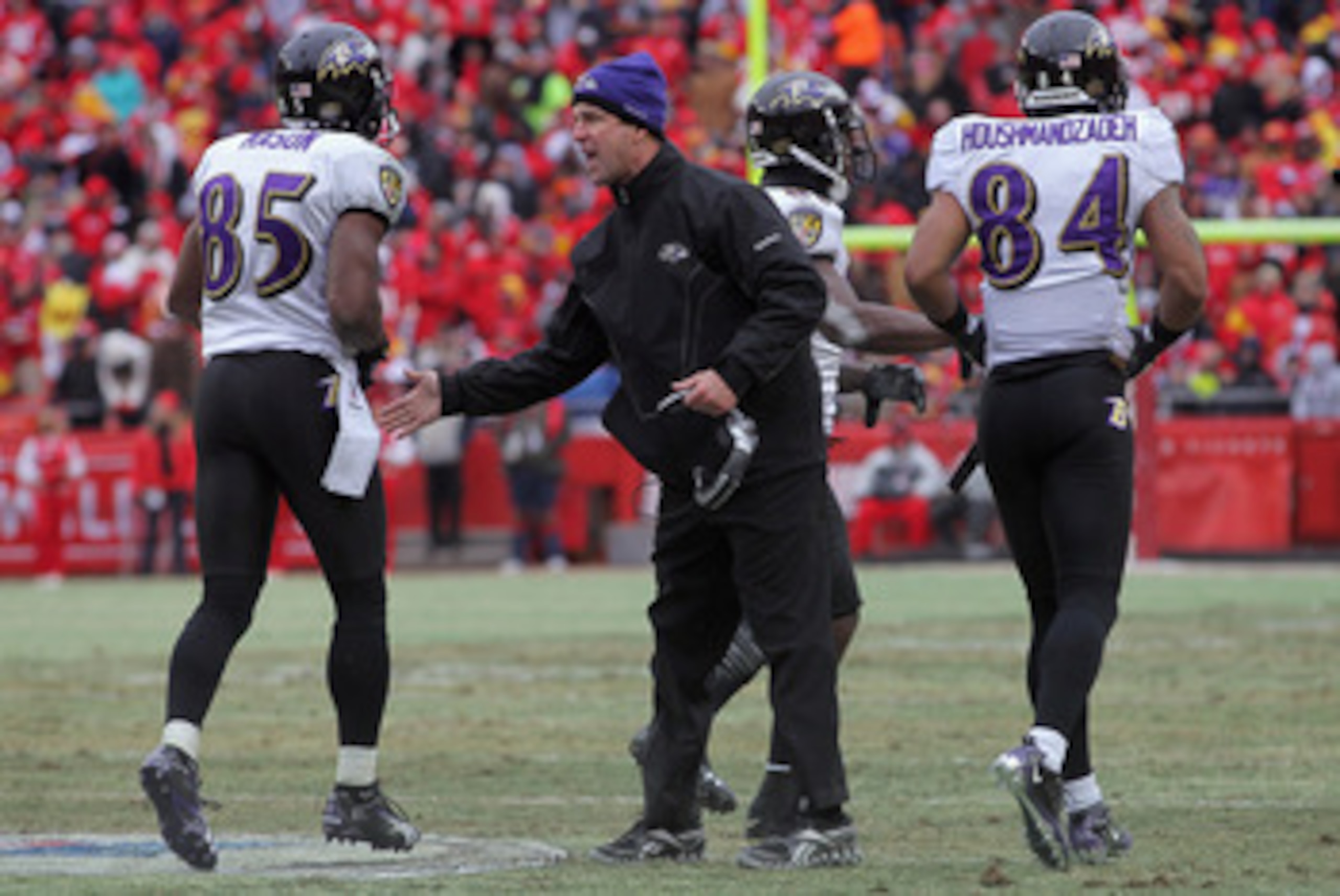 KANSAS CITY, MO - JANUARY 09: Head coach John Harbaugh of the Baltimore Ravens welcomes wide receivers Derrick Mason #85 and T.J. Houshmandzadeh back to the bench during their 2011 AFC wild card playoff game against the Kansas City Chiefs at Arrowhead Sta