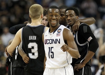 HOUSTON, TX - APRIL 04:  Kemba Walker #15 of the Connecticut Huskies smiles as the Butler Bulldogs huddle during the National Championship Game of the 2011 NCAA Division I Men's Basketball Tournament at Reliant Stadium on April 4, 2011 in Houston, Texas. 