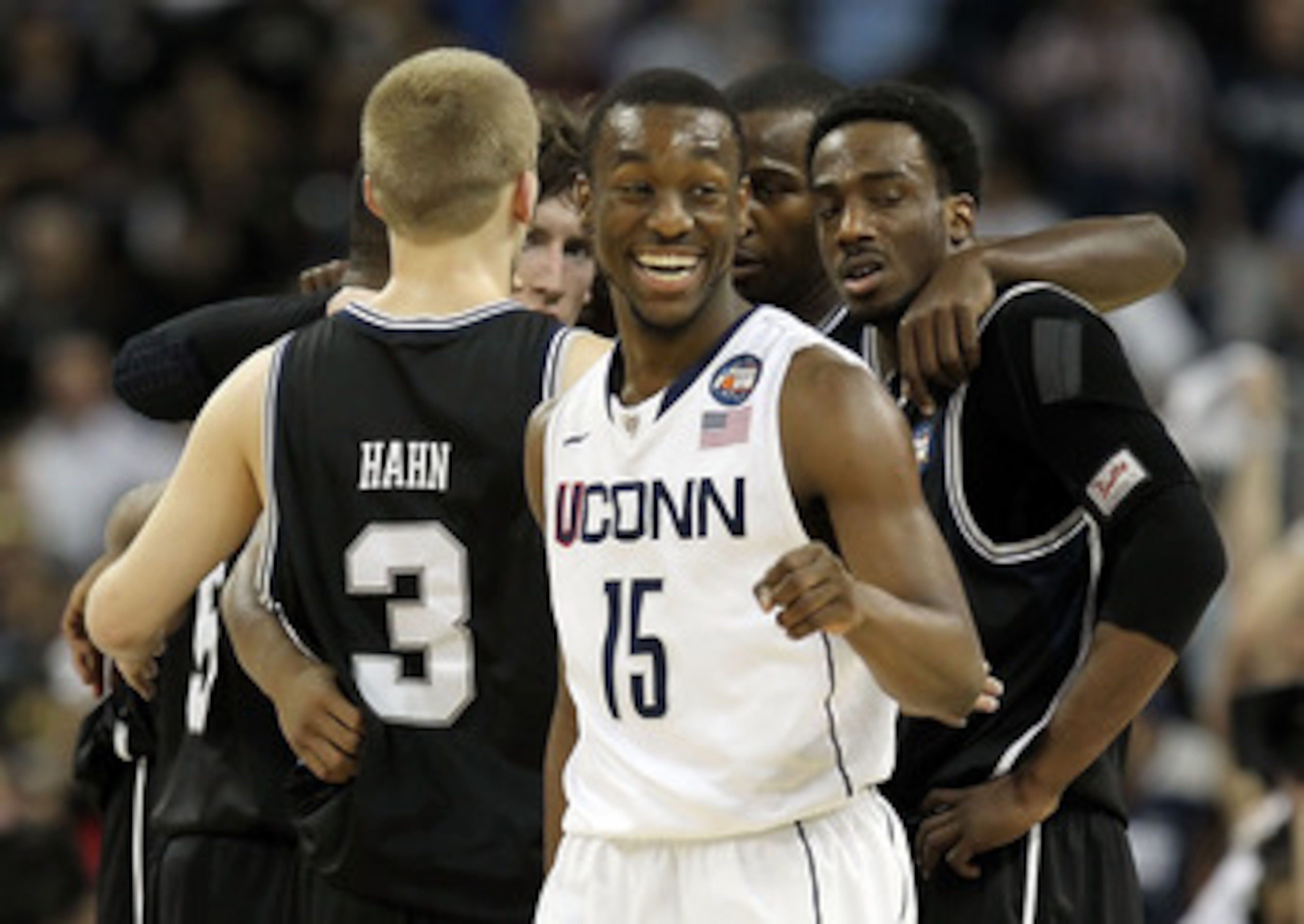 HOUSTON, TX - APRIL 04:  Kemba Walker #15 of the Connecticut Huskies smiles as the Butler Bulldogs huddle during the National Championship Game of the 2011 NCAA Division I Men's Basketball Tournament at Reliant Stadium on April 4, 2011 in Houston, Texas. 