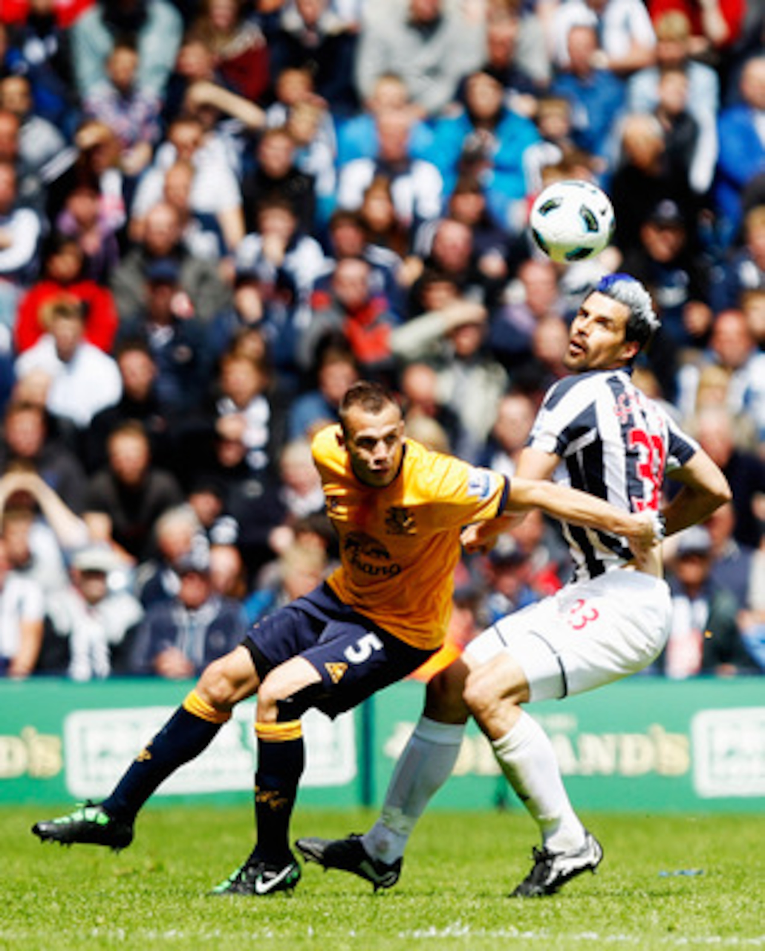 WEST BROMWICH, ENGLAND - MAY 14:  Paul Scharner of  West Bromwich Albion tangles with John Heitinga of Everton during the Barclays Premier League match between West Bromwich Albion and Everton at The Hawthorns on May 14, 2011 in West Bromwich, England.  (