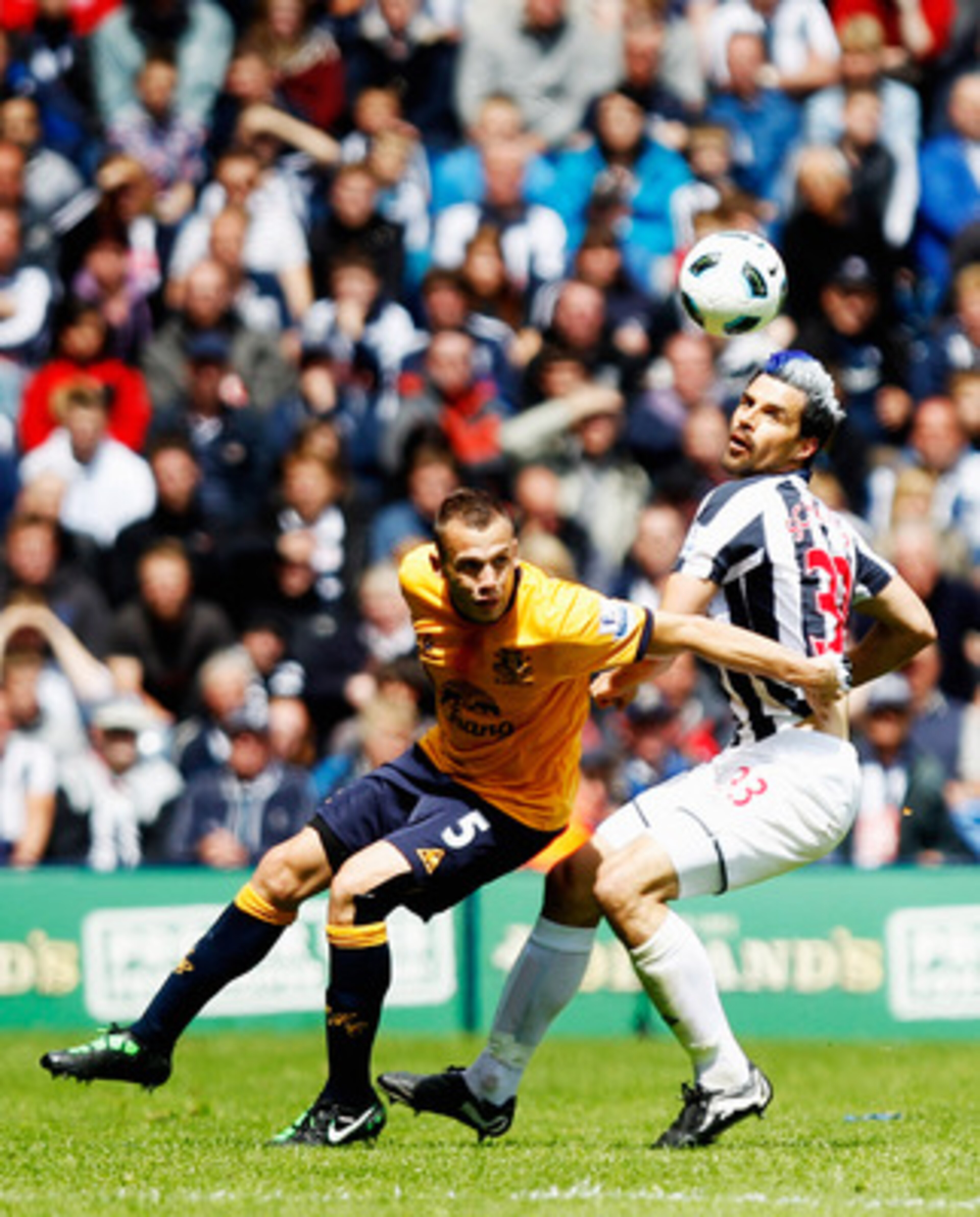 WEST BROMWICH, ENGLAND - MAY 14:  Paul Scharner of  West Bromwich Albion tangles with John Heitinga of Everton during the Barclays Premier League match between West Bromwich Albion and Everton at The Hawthorns on May 14, 2011 in West Bromwich, England.  (