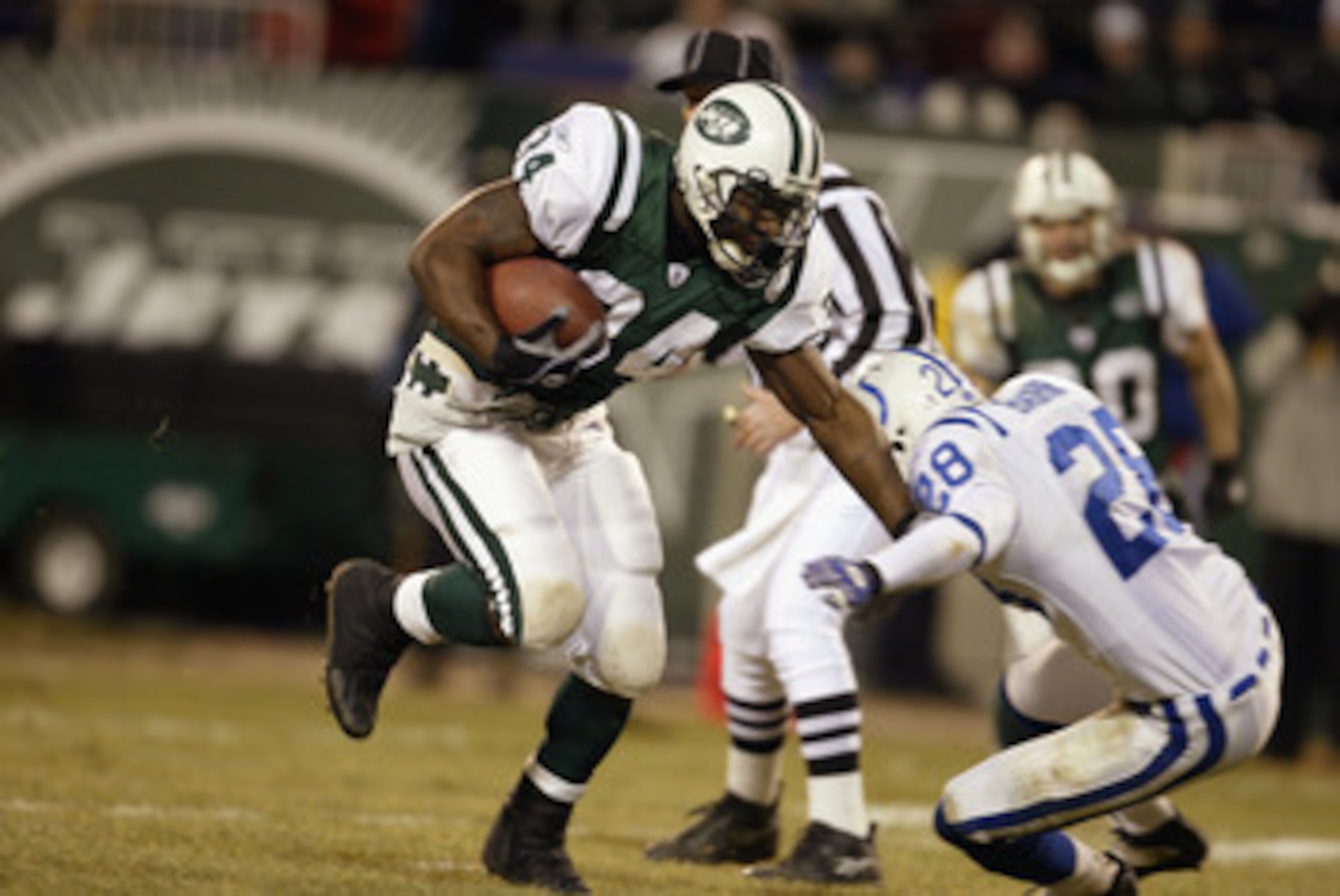 EAST RUTHERFORD, NJ - JANUARY 4:  LaMont Jordan #34 of the New York Jets runs past Idrees Bashir #28 of the Indianapolis Colts during the AFC wildcard game at Giants Stadium on January 4, 2003 in East Rutherford, New Jersey.  The Jets won 41-0.  (Photo by