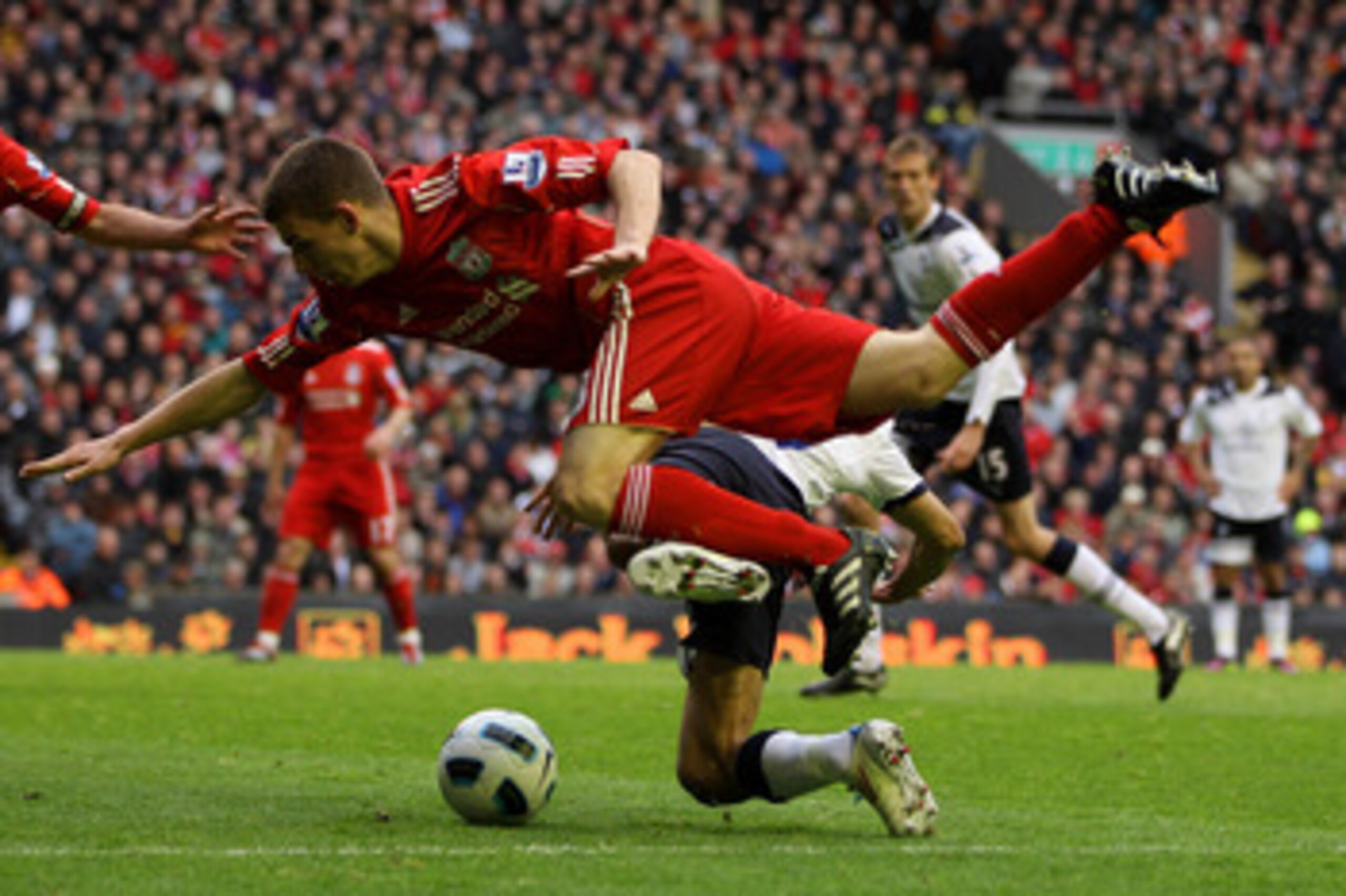 LIVERPOOL, ENGLAND - MAY 15:  John Flanagan of Liverpool brings down Steven Pienaar of Spurs to concede a penalty during the Barclays Premier League match between Liverpool and Tottenham Hotspur at Anfield on May 15, 2011 in Liverpool, England.  (Photo by