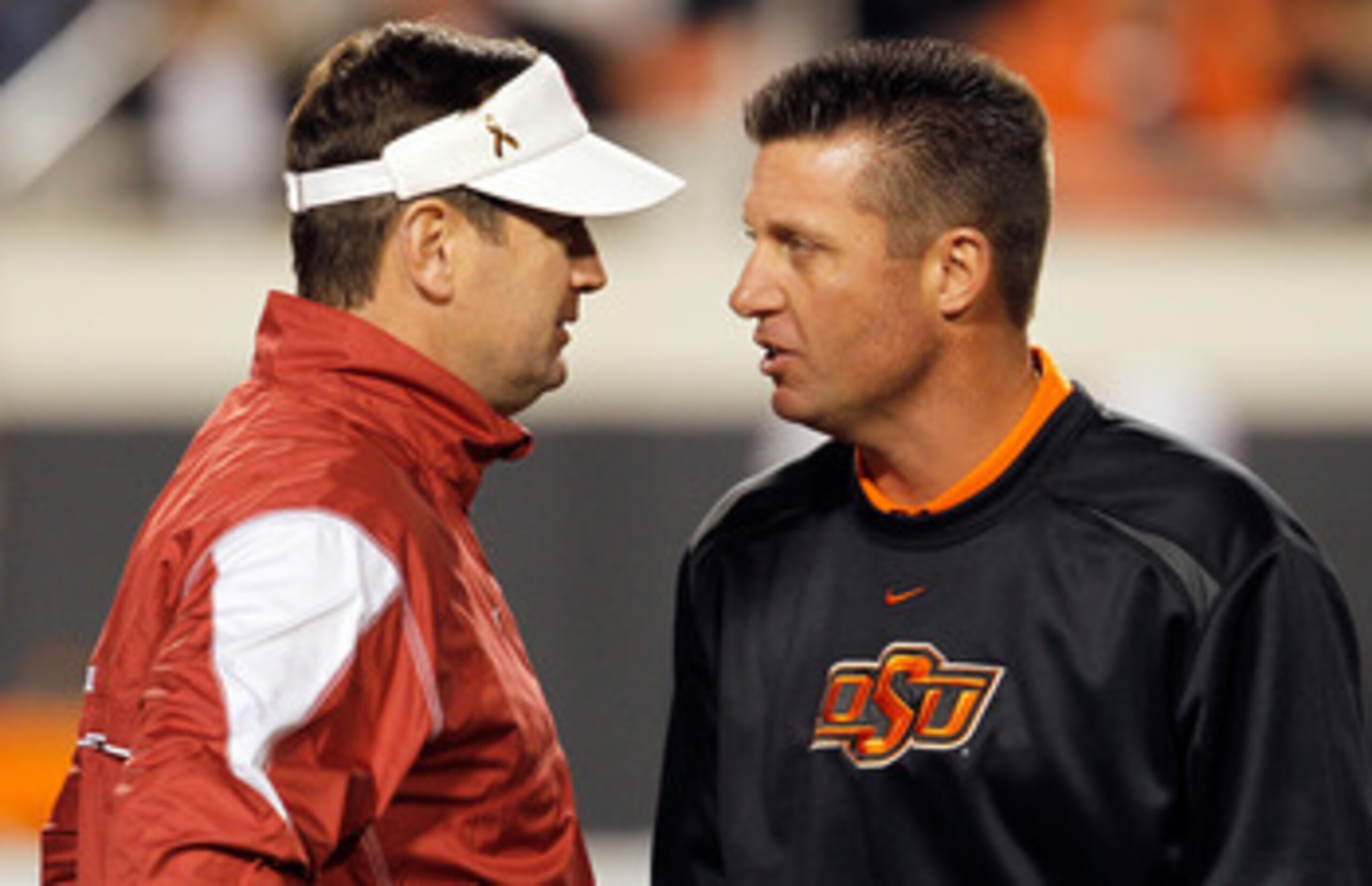 STILLWATER, OK - NOVEMBER 27:  Head coach Bob Stoops (L) of the Oklahoma Sooners talks with head coach Mike Gundy (R) of the Oklahoma State Cowboys at Boone Pickens Stadium on November 27, 2010 in Stillwater, Oklahoma.  (Photo by Tom Pennington/Getty Imag