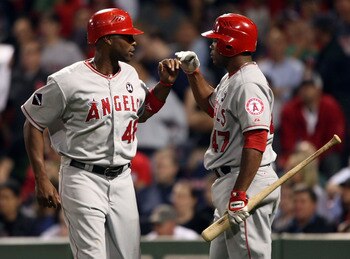 BOSTON - SEPTEMBER 15:  Torii Hunter #468 of the Los Angeles Angels of Anaheim is congratulated by teammate Howie Kendrick #47 after Hunter scored a run in the ninth inning against the Boston Red Sox on September 15, 2009 at Fenway Park in Boston, Massach