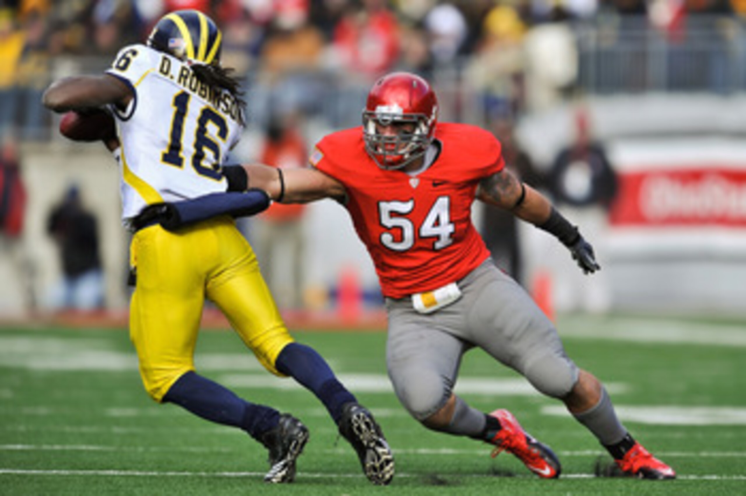 COLUMBUS, OH - NOVEMBER 27:  John Simon #54 of the Ohio State Buckeyes attempts to tackle quarterback Denard Robinson #16 of the Michigan Wolverines at Ohio Stadium on November 27, 2010 in Columbus, Ohio.  (Photo by Jamie Sabau/Getty Images)