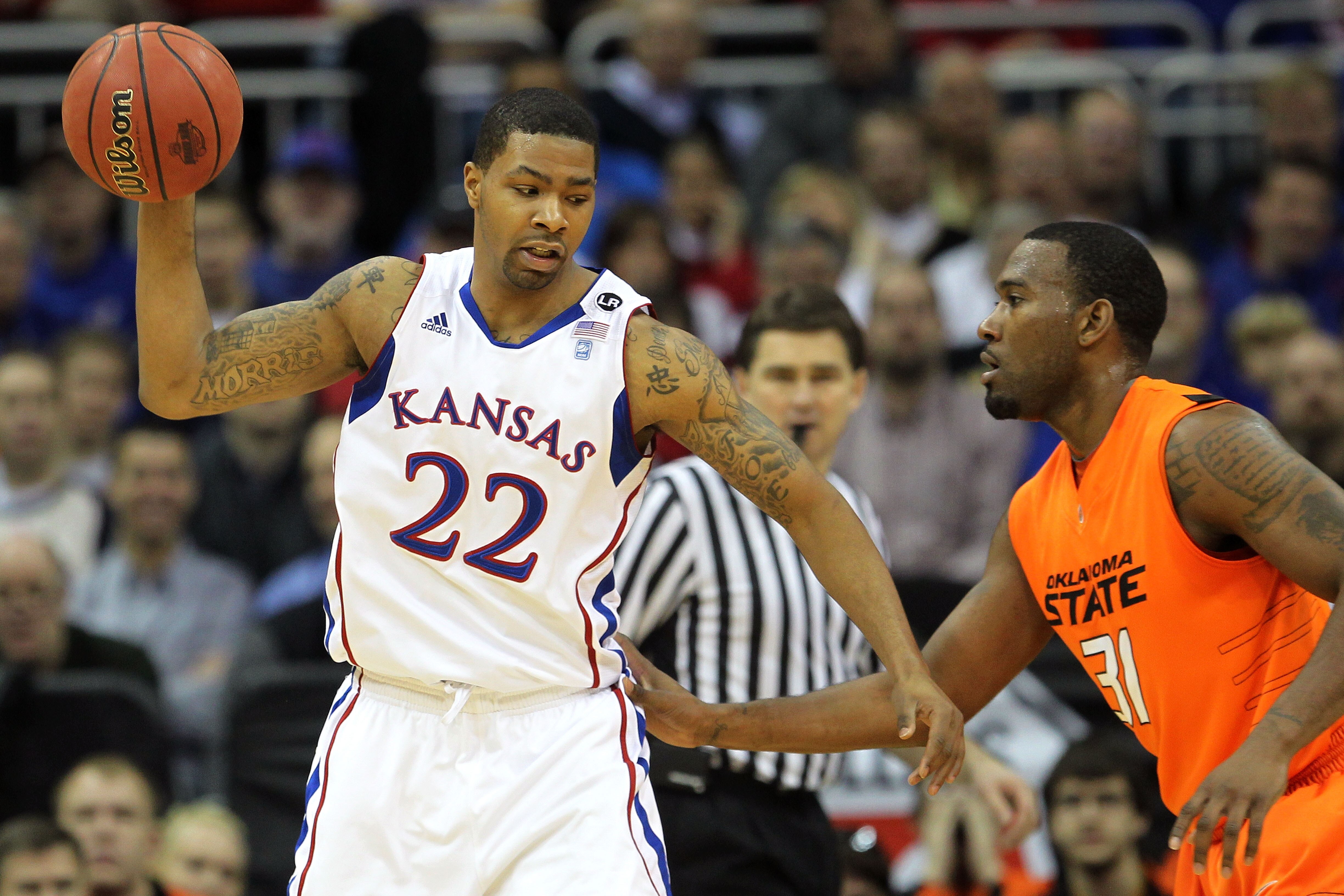KANSAS CITY, MO - MARCH 10:  Marcus Morris #22 of the Kansas Jayhawks looks to move the ball against Matt Pilgrim #31 of the Oklahoma State Cowboys during their quarterfinal game in the 2011 Phillips 66 Big 12 Men's Basketball Tournament at Sprint Center