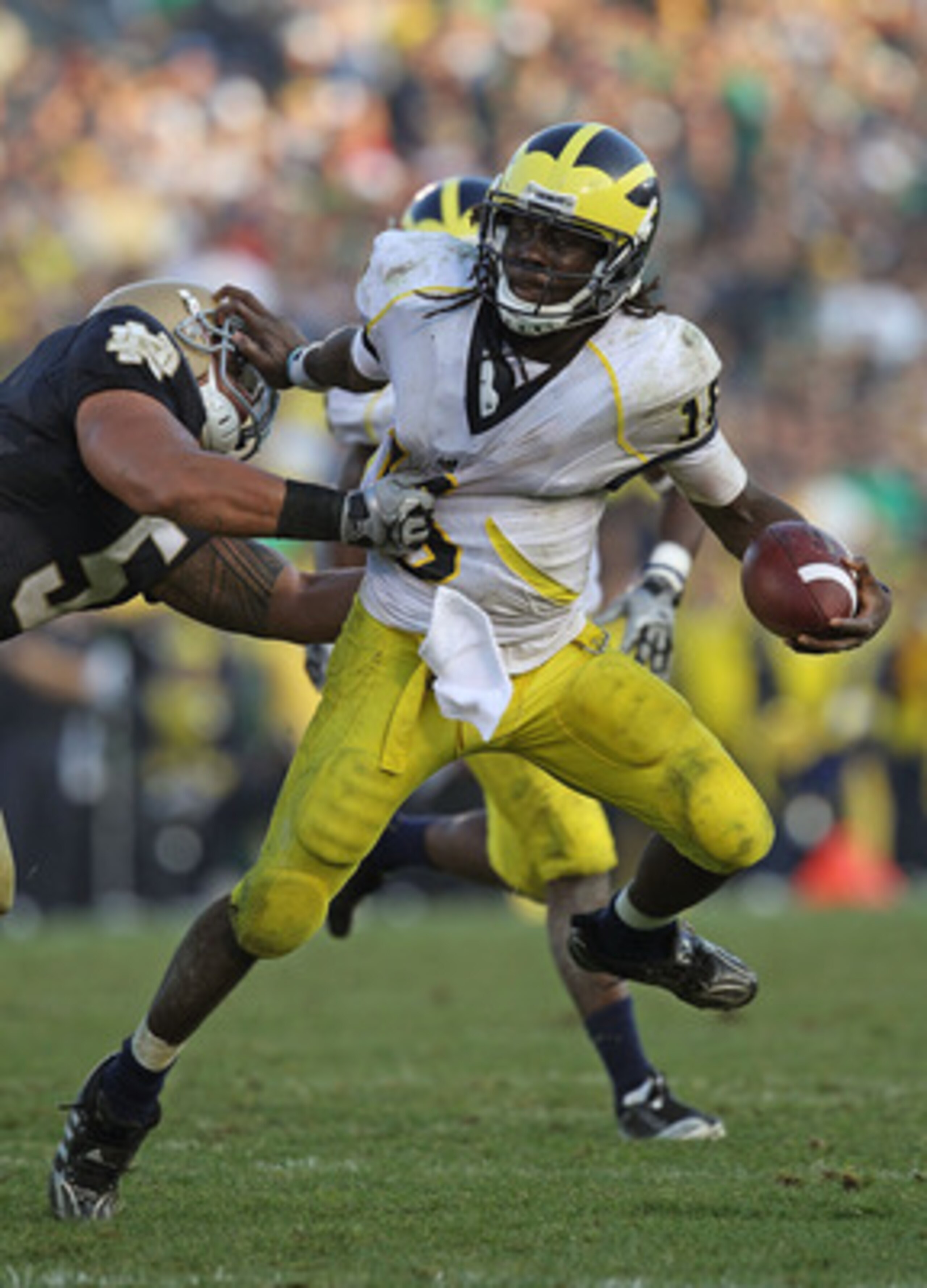 SOUTH BEND, IN - SEPTEMBER 11: Denard Robinson #16 of the Michigan Wolverines pushes off a tackle attempt by Manti Te'o #5 of the Notre Dame Fighting Irish in the final minute at Notre Dame Stadium on September 11, 2010 in South Bend, Indiana. Michigan de