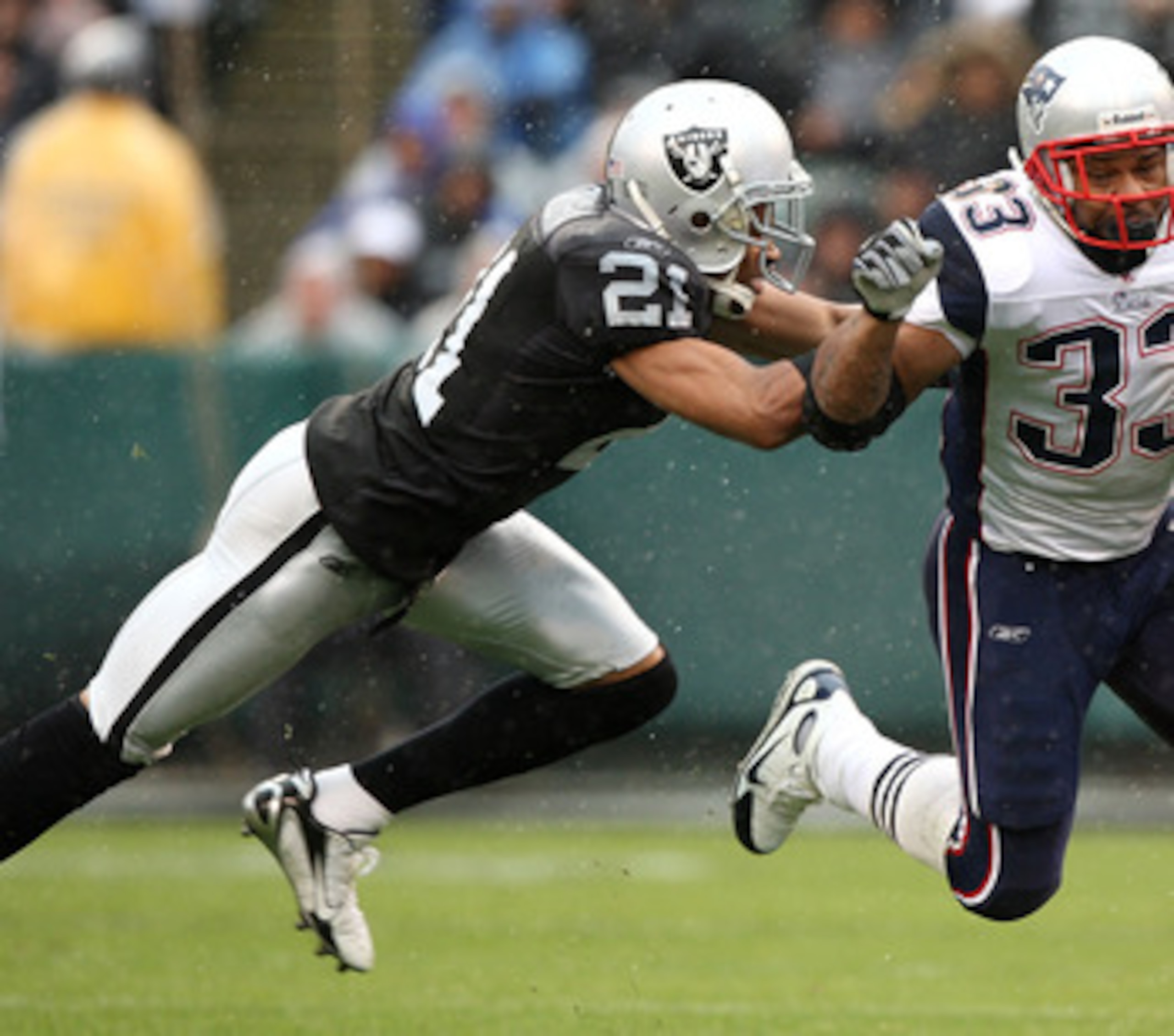 OAKLAND, CA - DECEMBER 14: Kevin Faulk #33 of the New England Patriots runs with the ball as Nnamdi Asomugha #21 of the Oakland Raiders defends during an NFL game on December 14, 2008 at the Oakland-Alameda County Coliseum in Oakland, California.  (Photo