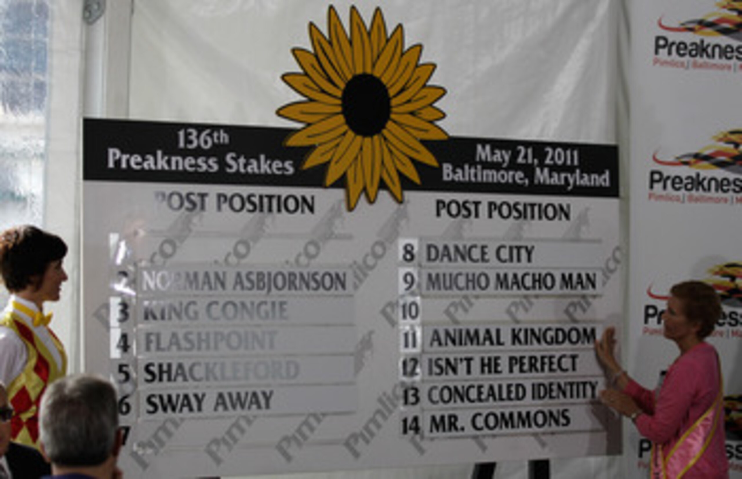 BALTIMORE, MD - MAY 18: Susan Faber (R) places the name of Kentucky Derby winner and Preakness entrant Animal Kingdom on the board during the post position draw for the 136th running of the Preakness Stakes at  Pimlico Race Course on May 18, 2011 in Balti