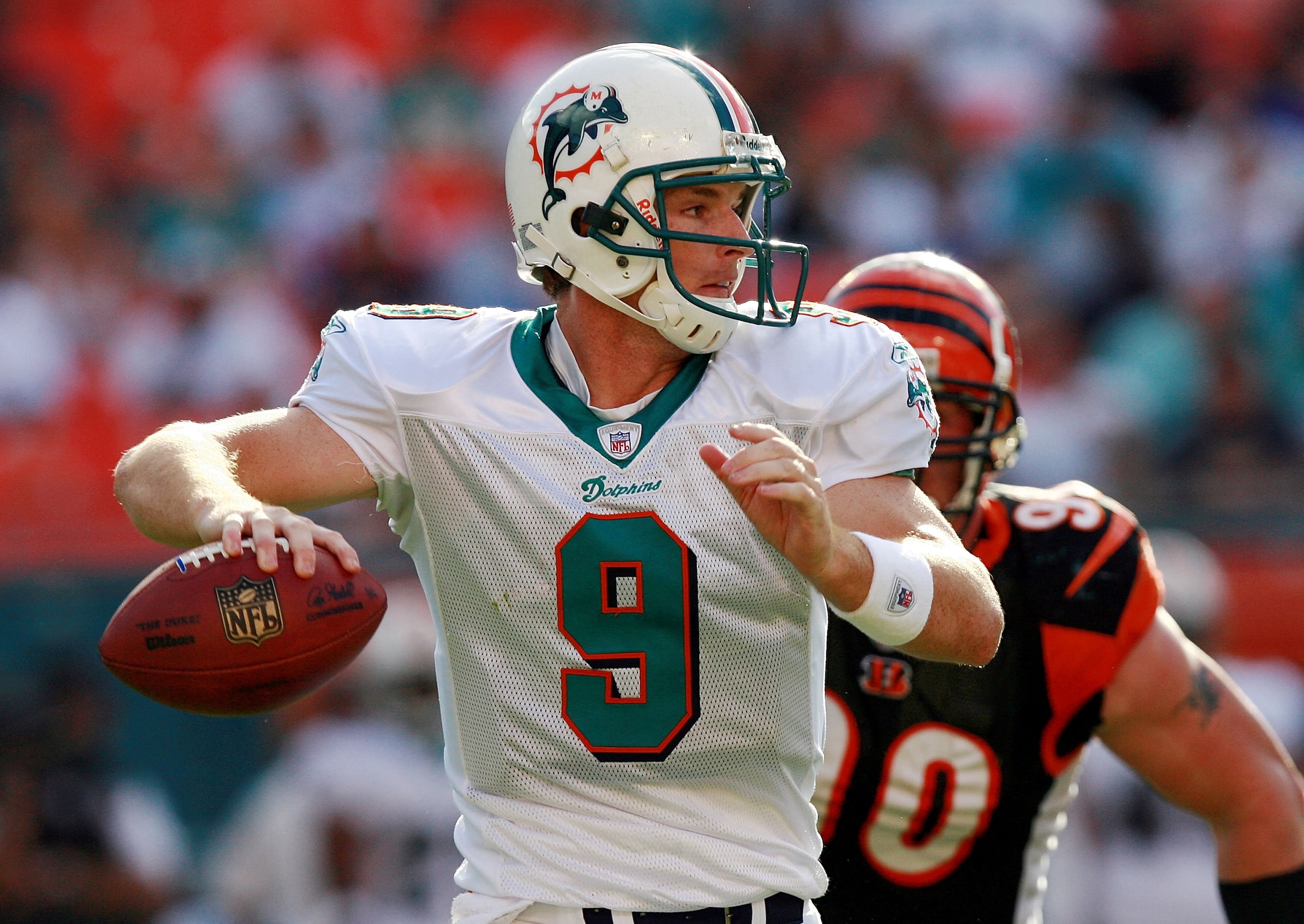 MIAMI - DECEMBER 30:  Quarterback John Beck #9 of the Miami Dolphins throws a pass while being chased by defensive end Justin Smith #90 of the Cincinnati Bengals at Dolphin Stadium on December 30, 2007 in Miami, Florida. The Bengals defeated the Dolphins