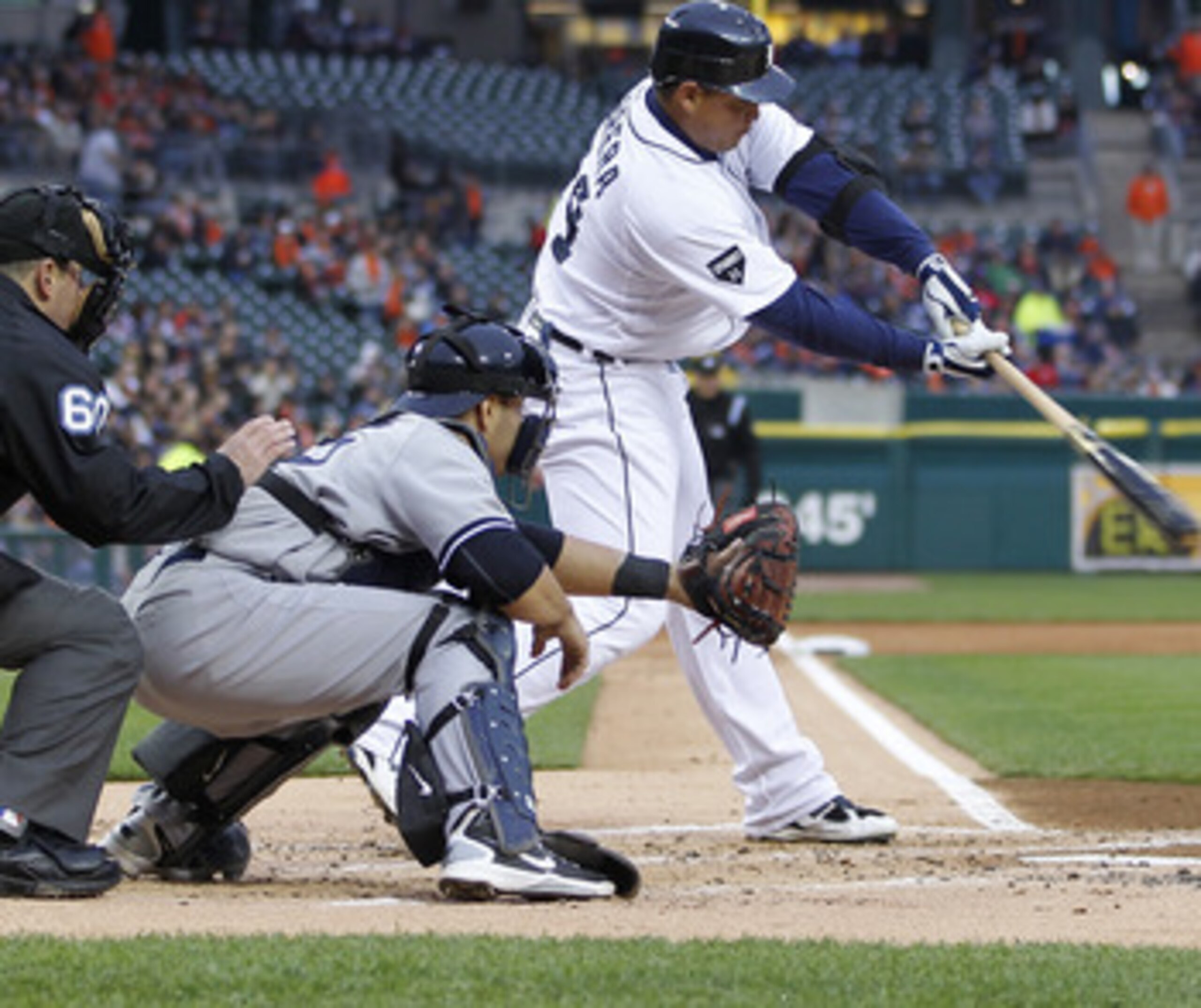 DETROIT, MI - MAY 03: Miguel Cabrera #24 of the Detroit Tigers hits a sacrifice fly to score Scott Sizemore #20 in the first inning in front of Russell Martin #55 of the New York Yankees at Comerica Park on May 3, 2011 in Detroit, Michigan. Detroit won th
