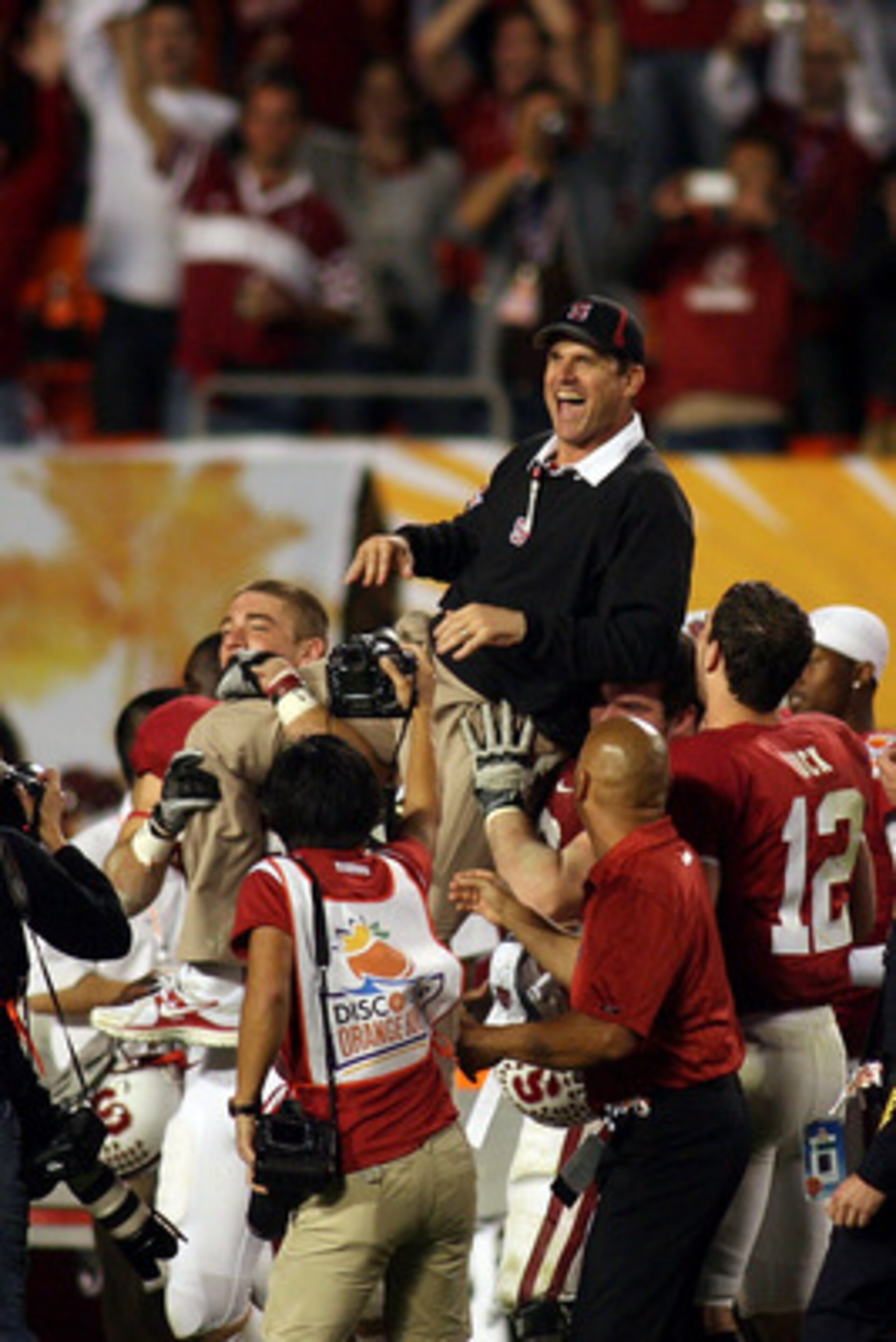 MIAMI, FL - JANUARY 03:  Head coach Jim Harbaugh of the Stanford Cardinal is lifted up by his players as they celebrate their 40-12 win against the Virginia Tech Hokies during the 2011 Discover Orange Bowl at Sun Life Stadium on January 3, 2011 in Miami, 