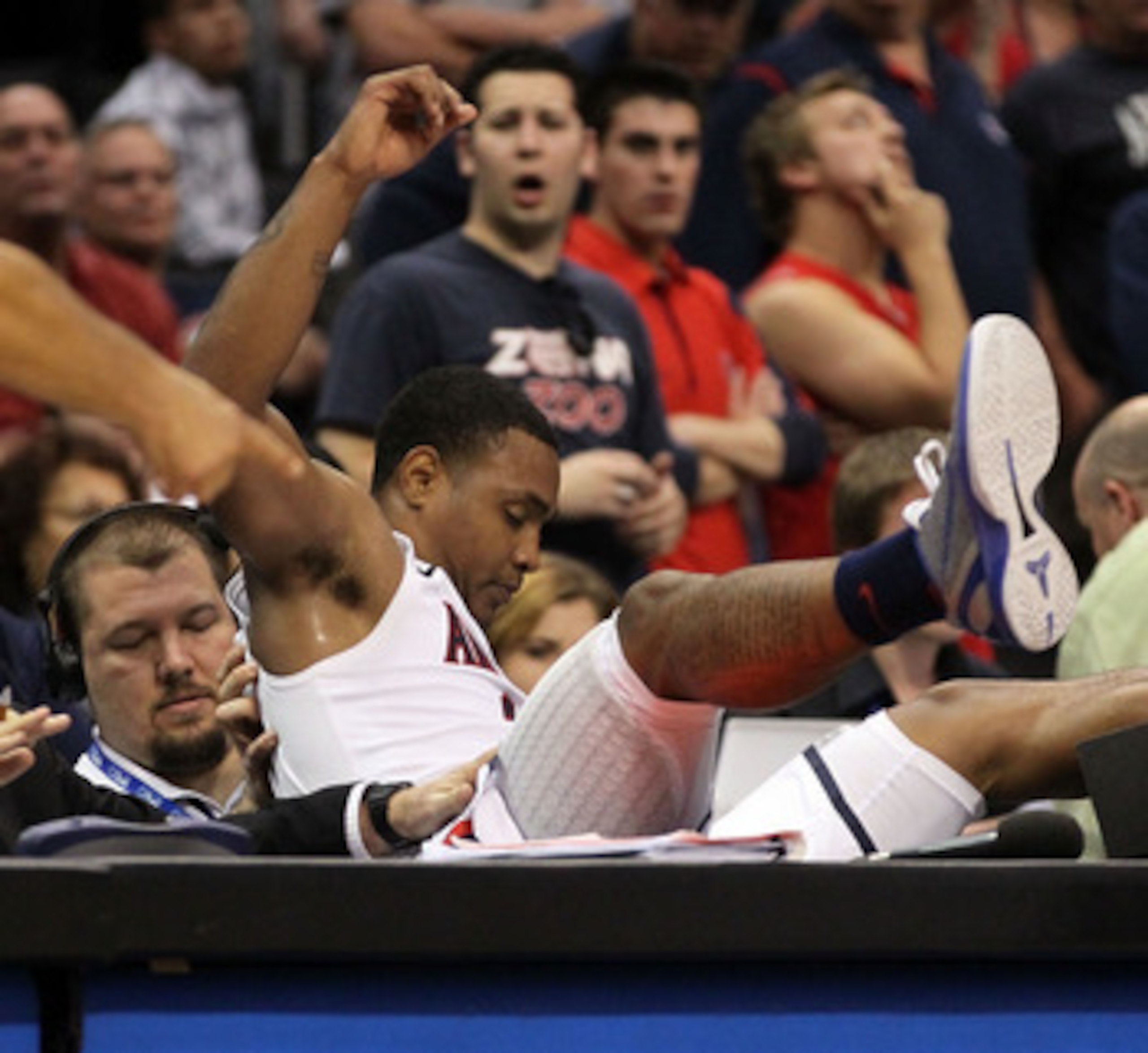 LOS ANGELES, CA - MARCH 12: Lamont Jones #12 of the Arizona Wildcats falls into the scorer's table in overtime while taking on the Washington Huskies the championship game of the 2011 Pacific Life Pac-10 Men's Basketball Tournament at Staples Center on M LOS ANGELES, CA - MARCH 12: Lamont Jones #12 of the Arizona Wildcats falls into the scorer's table in overtime while taking on the Washington Huskies the championship game of the 2011 Pacific Life Pac-10 Men's Basketball Tournament at Staples Center on M