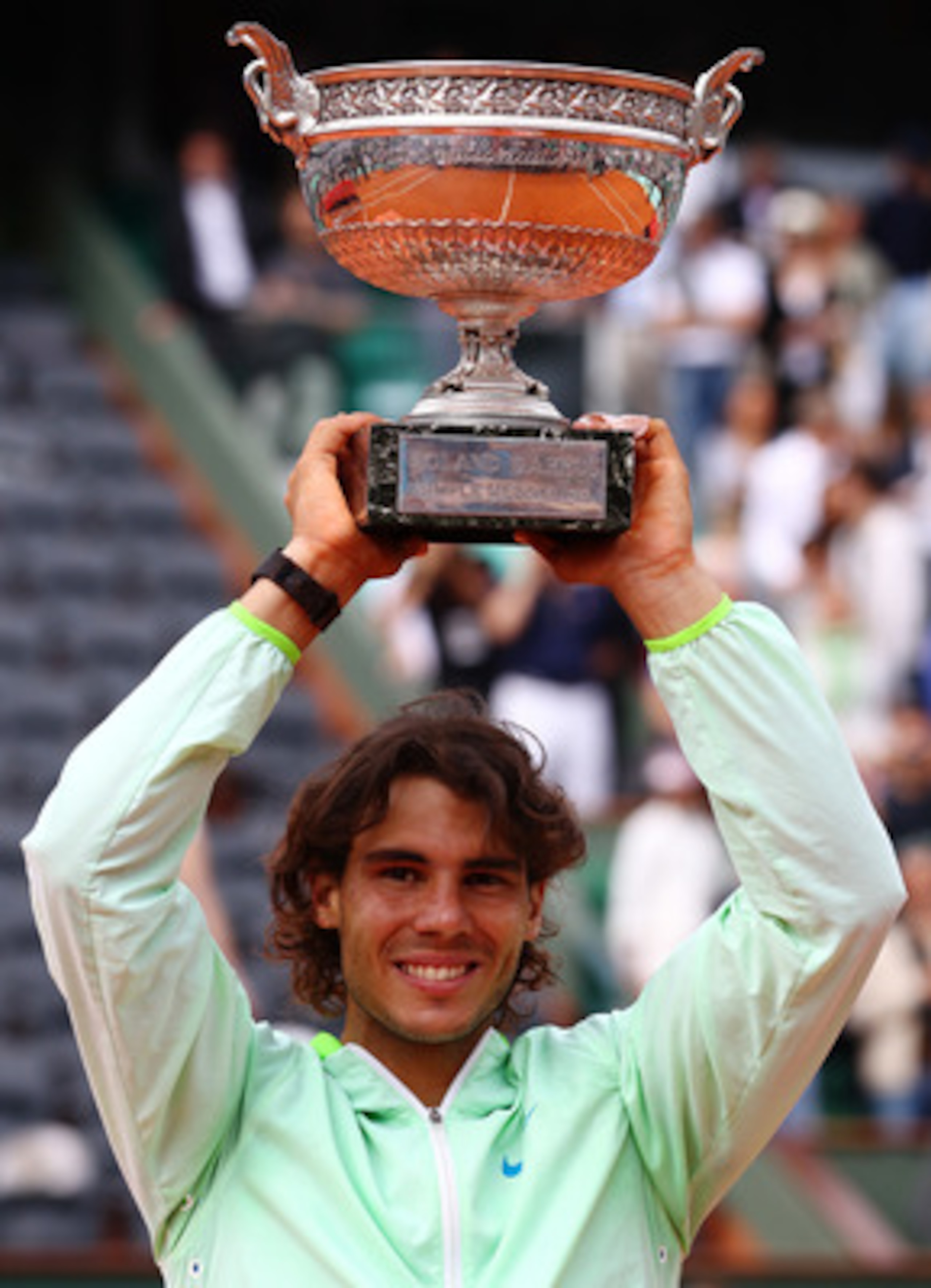 PARIS - JUNE 06: Rafael Nadal of Spain celebrates with the trophy after winning the men's singles final match between Rafael Nadal of Spain and Robin Soderling of Sweden on day fifteen of the French Open at Roland Garros on June 6, 2010 in Paris, France. PARIS - JUNE 06: Rafael Nadal of Spain celebrates with the trophy after winning the men's singles final match between Rafael Nadal of Spain and Robin Soderling of Sweden on day fifteen of the French Open at Roland Garros on June 6, 2010 in Paris, France.