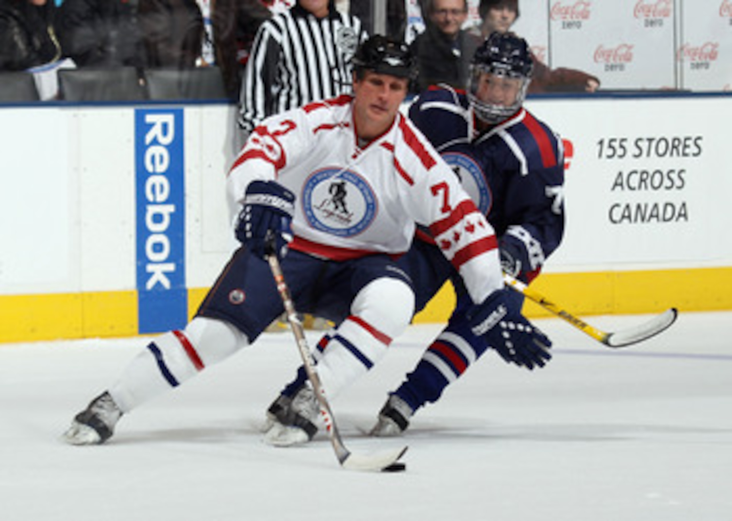 TORONTO, ON - NOVEMBER 07: Paul Coffey #77 of the Canada Legends moves the puck around Sue Merz of the USA Legends at the Legends Classic Hockey Game at the Air Canada Centre on November 7, 2010 in Toronto, Canada.  (Photo by Bruce Bennett/Getty Images)