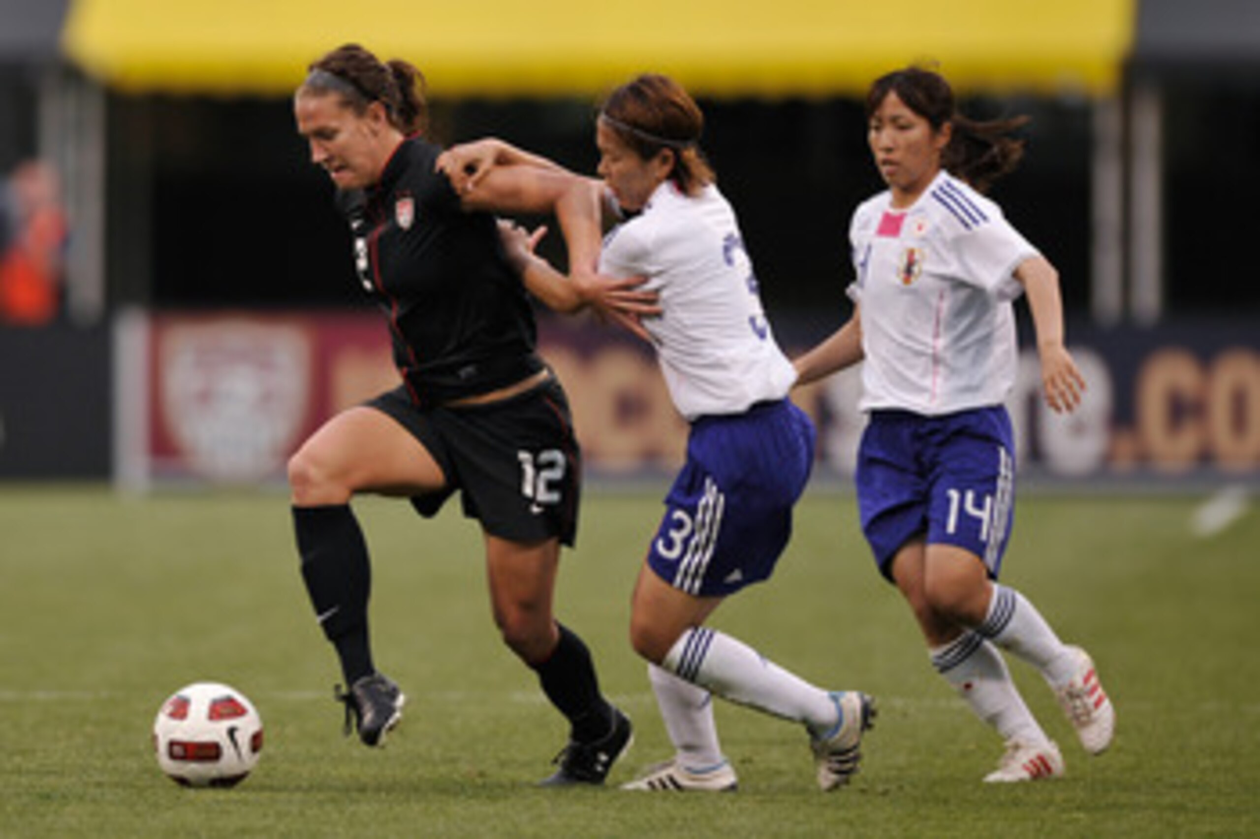 COLUMBUS, OH - MAY 14:  Lauren Cheney #12 of the United States controls the ball in the second half as Azusa Iwashimizu #3 of Japan and Emi Nakajima #14 of Japan defend on May 14, 2011 at Crew Stadium in Columbus, Ohio. USA defeated Japan 2-0.   (Photo by