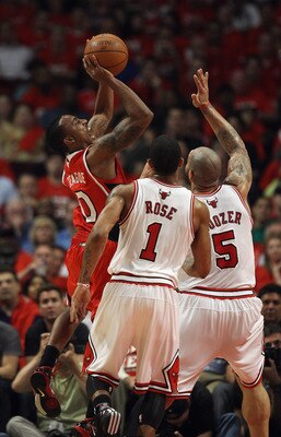 CHICAGO, IL - MAY 10: Jeff Teague #0 of the Atlanta Hawks puts up a shot against Carlos Boozer #5 and Derrick Rose #1 of the Chicago Bulls in Game Five of the Eastern Conference Semifinals in the 2011 NBA Playoffs at the United Center on May 10, 2011 in C