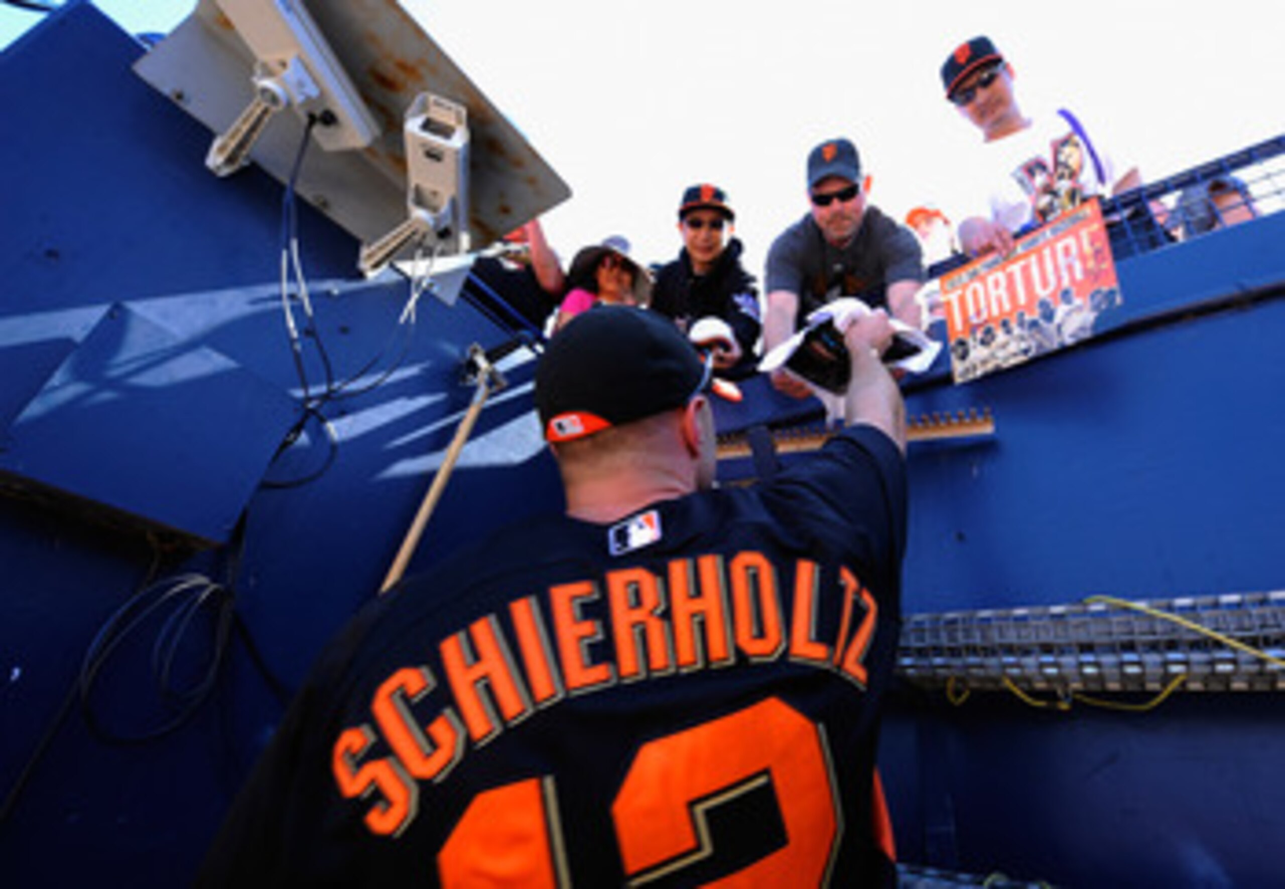 PEORIA, AZ - MARCH 08:  Nate Schierholtz #12 of the San Francisco Giants signs programs for fans prior to the start of the spring training baseball game against Seattle Mariners at Peoria Stadium on March 8, 2011 in Peoria, Arizona.  (Photo by Kevork Djan