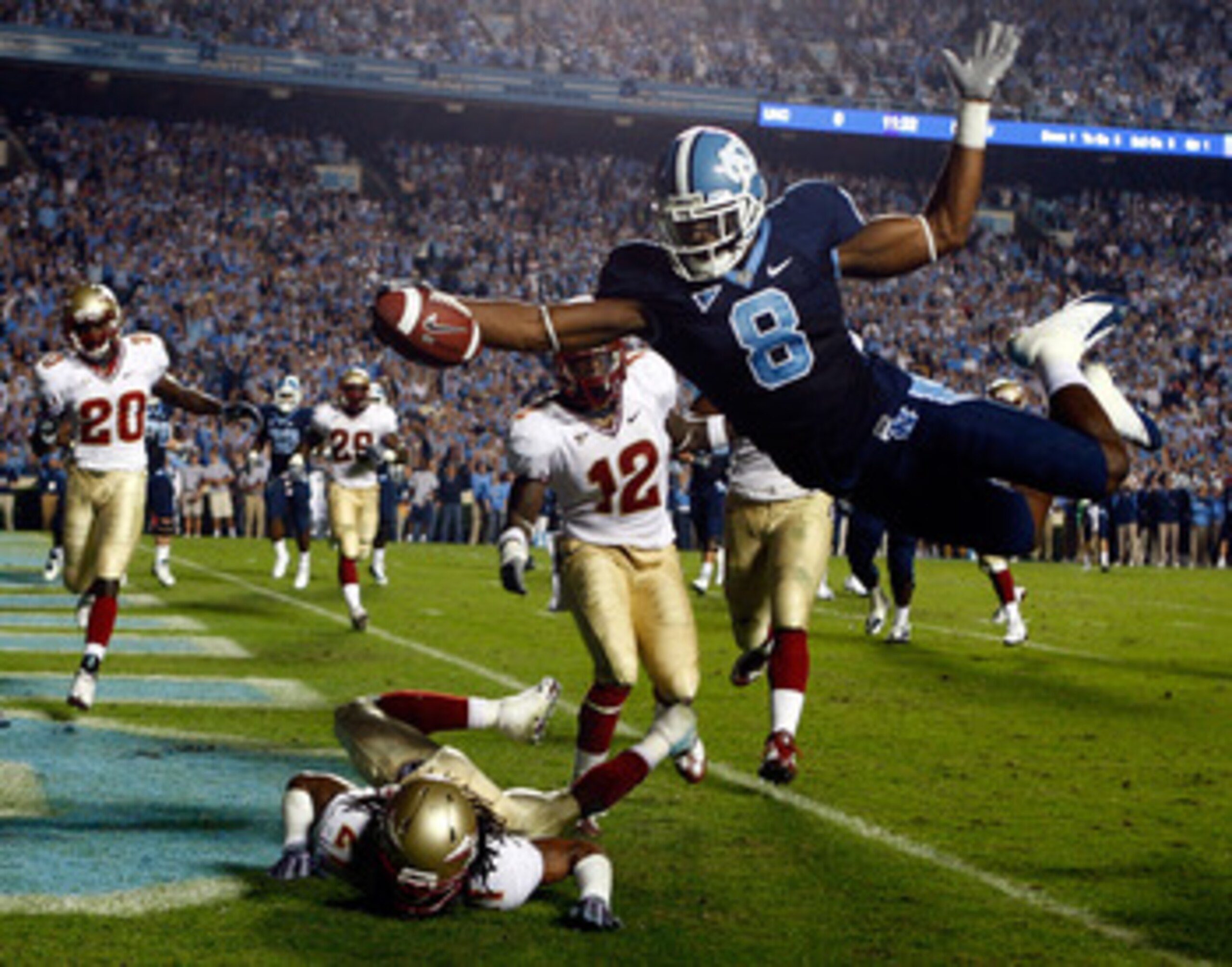 CHAPEL HILL, NC - OCTOBER 22:  Greg Little #8 of the North Carolina Tar Heels dives past Florida State Seminole defenders Patrick Robinson #21 and Nigel Carr #12 for a first quarter touchdown at Kenan Stadium on October 22, 2009 in Chapel Hill, North Caro