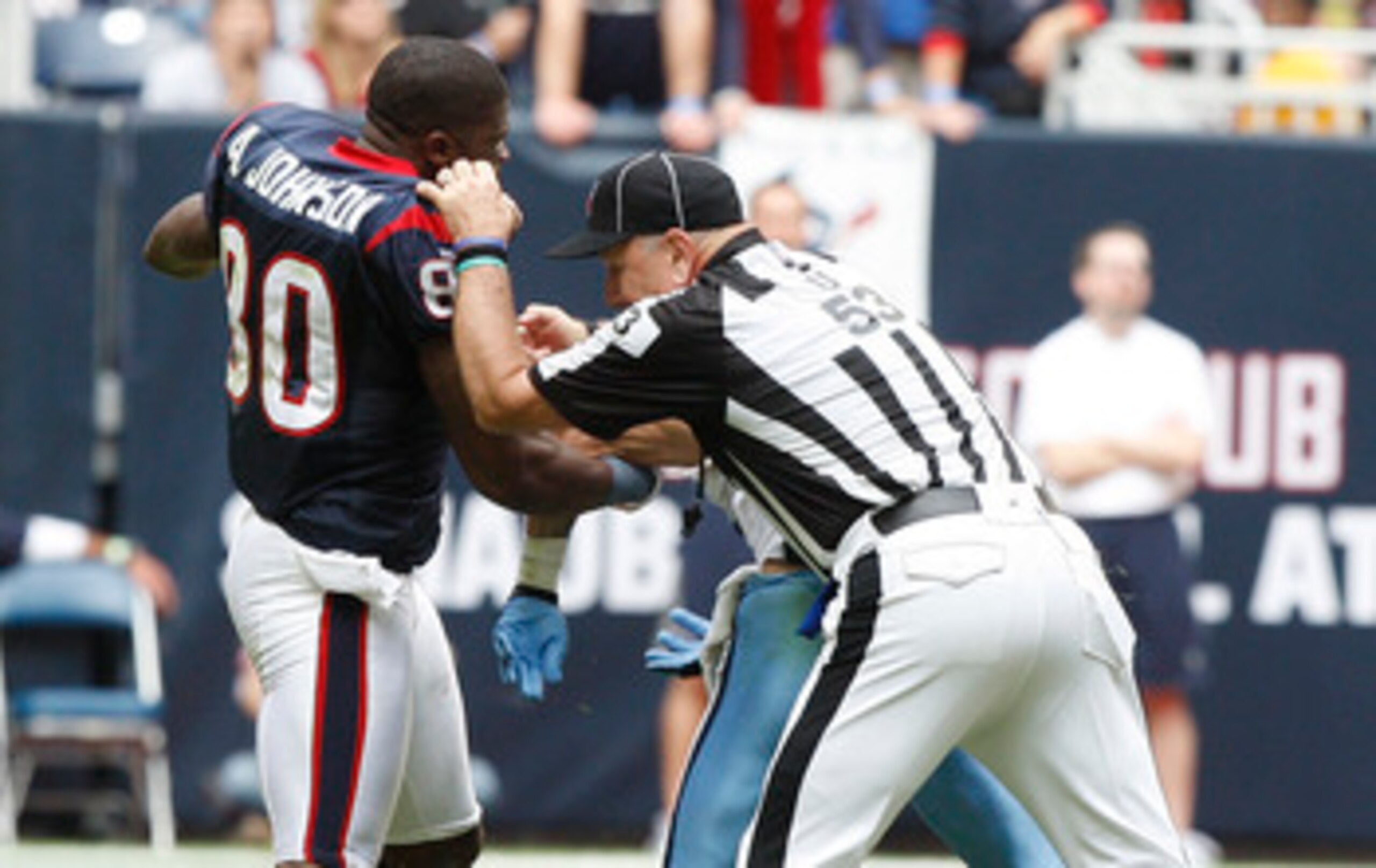 HOUSTON - NOVEMBER 28:  Wide receiver Andre Johnson #80 of the Houston Texans is separated by umpire Garth DeFerlice #53 from cornerback Cortland Finnegan #31 of the Tennessee Titans after the two exchanged punches in the fourth quarter at Reliant Stadium