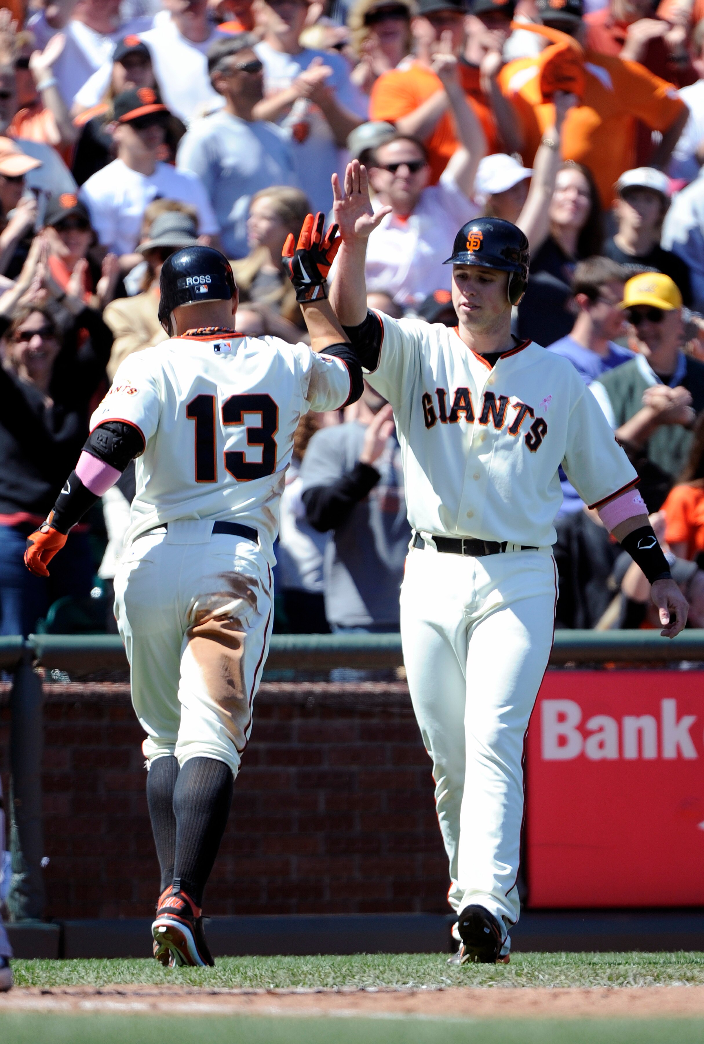 SAN FRANCISCO, CA - MAY 8: Cody Ross #13 of the San Francisco Giants high-fives Buster Posey #28  after hitting a two-run homer in the bottom of the six inning against the Colorado Rockies during a MLB baseball game at AT&T Park May 8, 2011 in San Francis