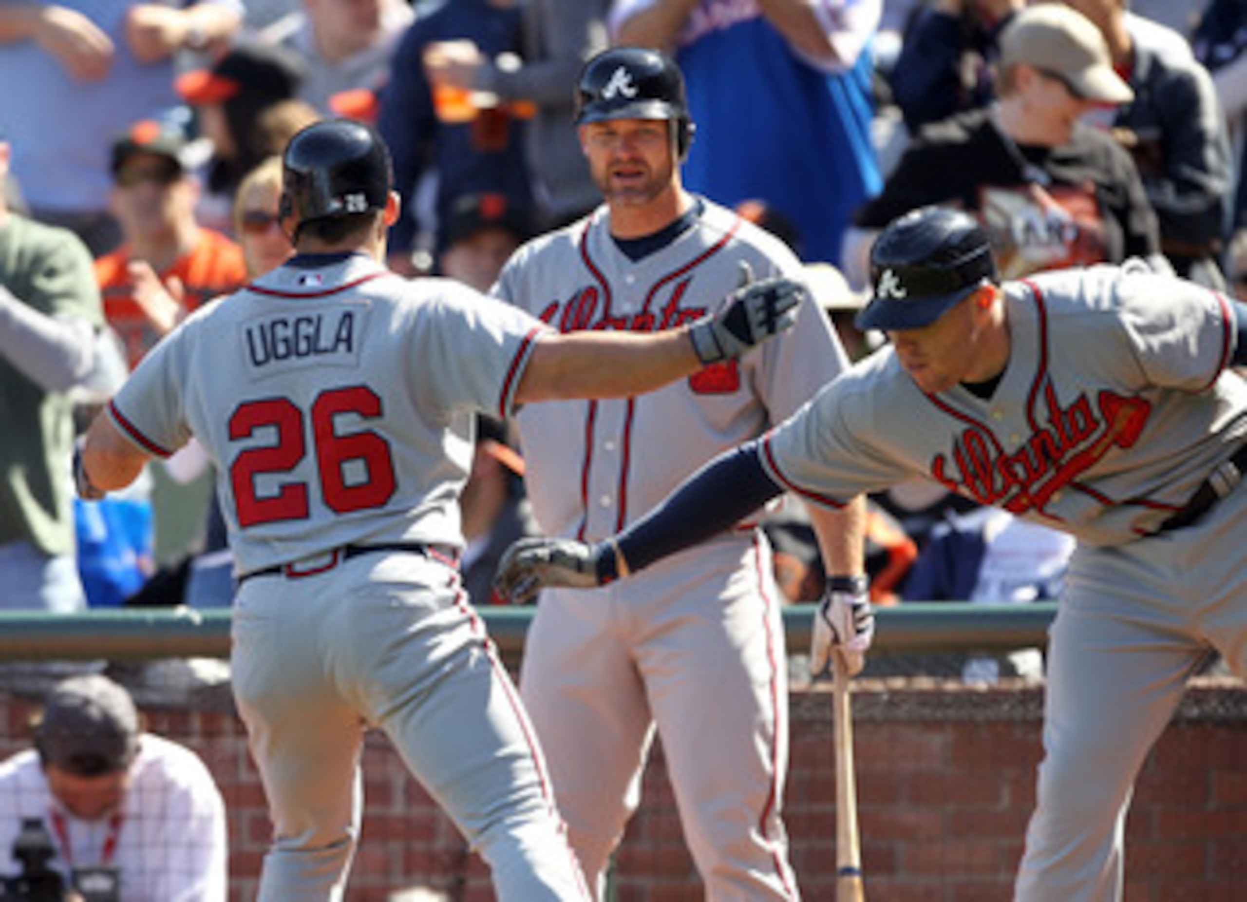 SAN FRANCISCO, CA - APRIL 24:  Dan Uggla #26 of the Atlanta Braves is congratulated by Freddie Freeman #5 and David Ross #8 after he hits a a home run to tie the game 6-6 in the eighth inning at AT&T Park on April 24, 2011 in San Francisco, California.  (