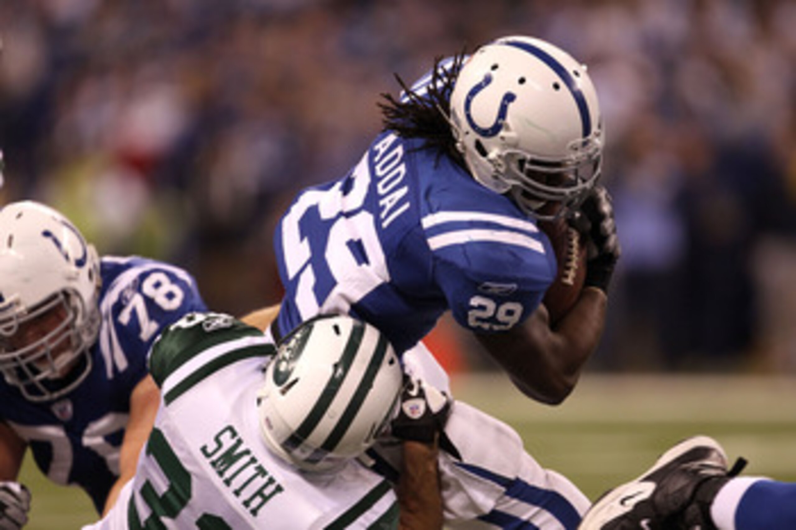 INDIANAPOLIS, IN - JANUARY 08:  Joseph Addai #29 of the Indianapolis Colts runs the ball against Eric Smith #33 of the New York Jets during their 2011 AFC wild card playoff game at Lucas Oil Stadium on January 8, 2011 in Indianapolis, Indiana. The Jets wo