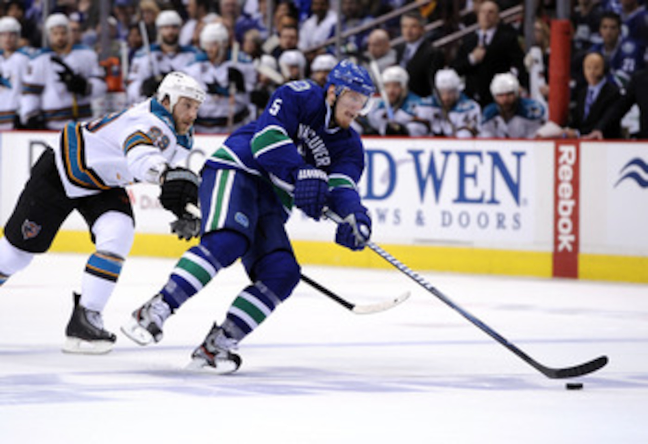 VANCOUVER, CANADA - MAY 15: Christian Ehrhoff #5 of the Vancouver Canucks controls the puck under pressure from Ryane Clowe #29 of the San Jose Sharks in Game One of the Western Conference Finals during the 2011 Stanley Cup Playoffs at Rogers Arena on Ma VANCOUVER, CANADA - MAY 15: Christian Ehrhoff #5 of the Vancouver Canucks controls the puck under pressure from Ryane Clowe #29 of the San Jose Sharks in Game One of the Western Conference Finals during the 2011 Stanley Cup Playoffs at Rogers Arena on Ma