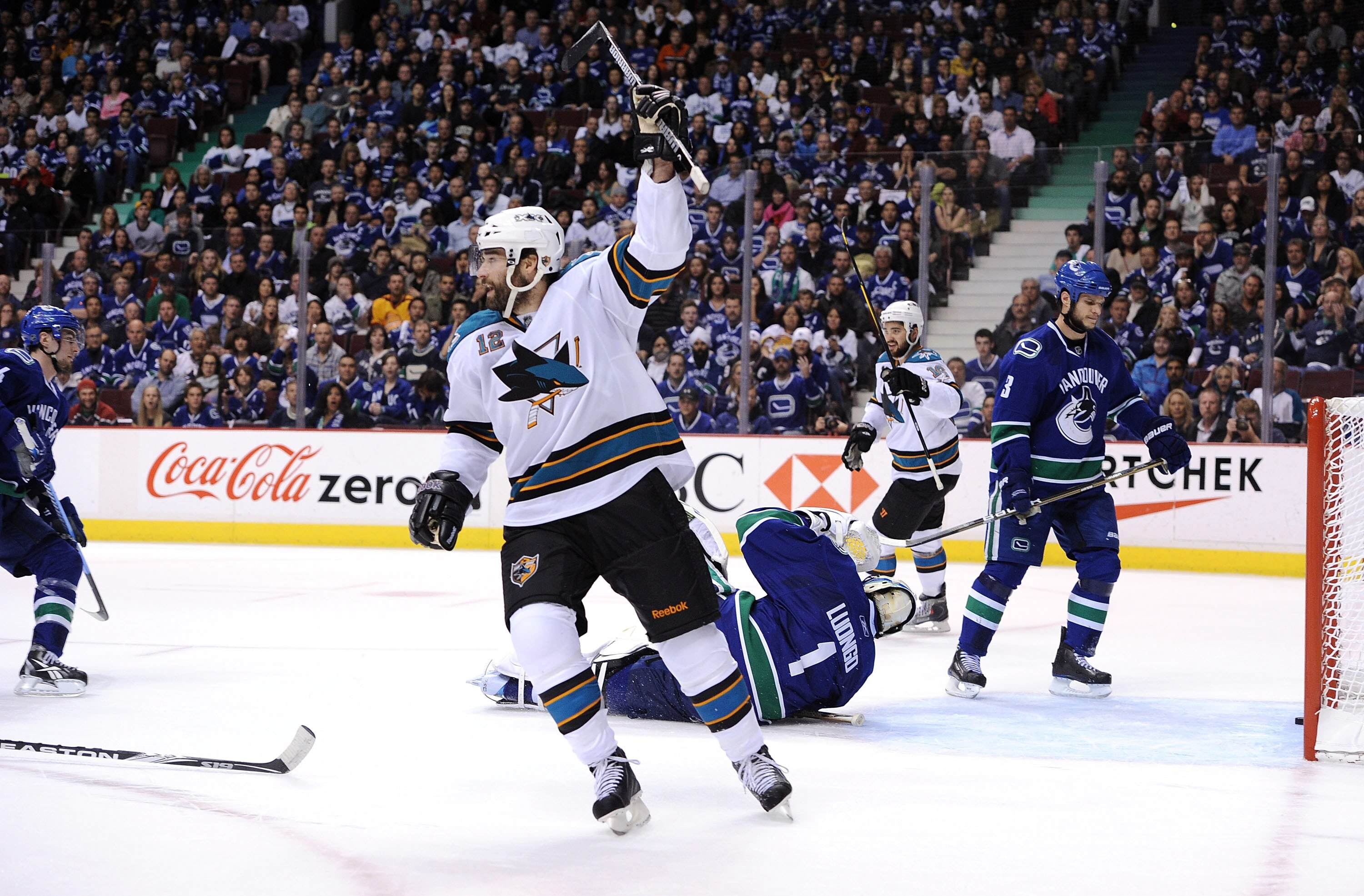 VANCOUVER, BC - MAY 15:  Patrick Marleau #12 and Devin Setoguchi #16 of the San Jose Sharks react after a goal by teammate Joe Thornton #19 (not in photo) as Kevin Bieksa #3 of the Vancouver Canucks looks on in the first period in Game One of the Western