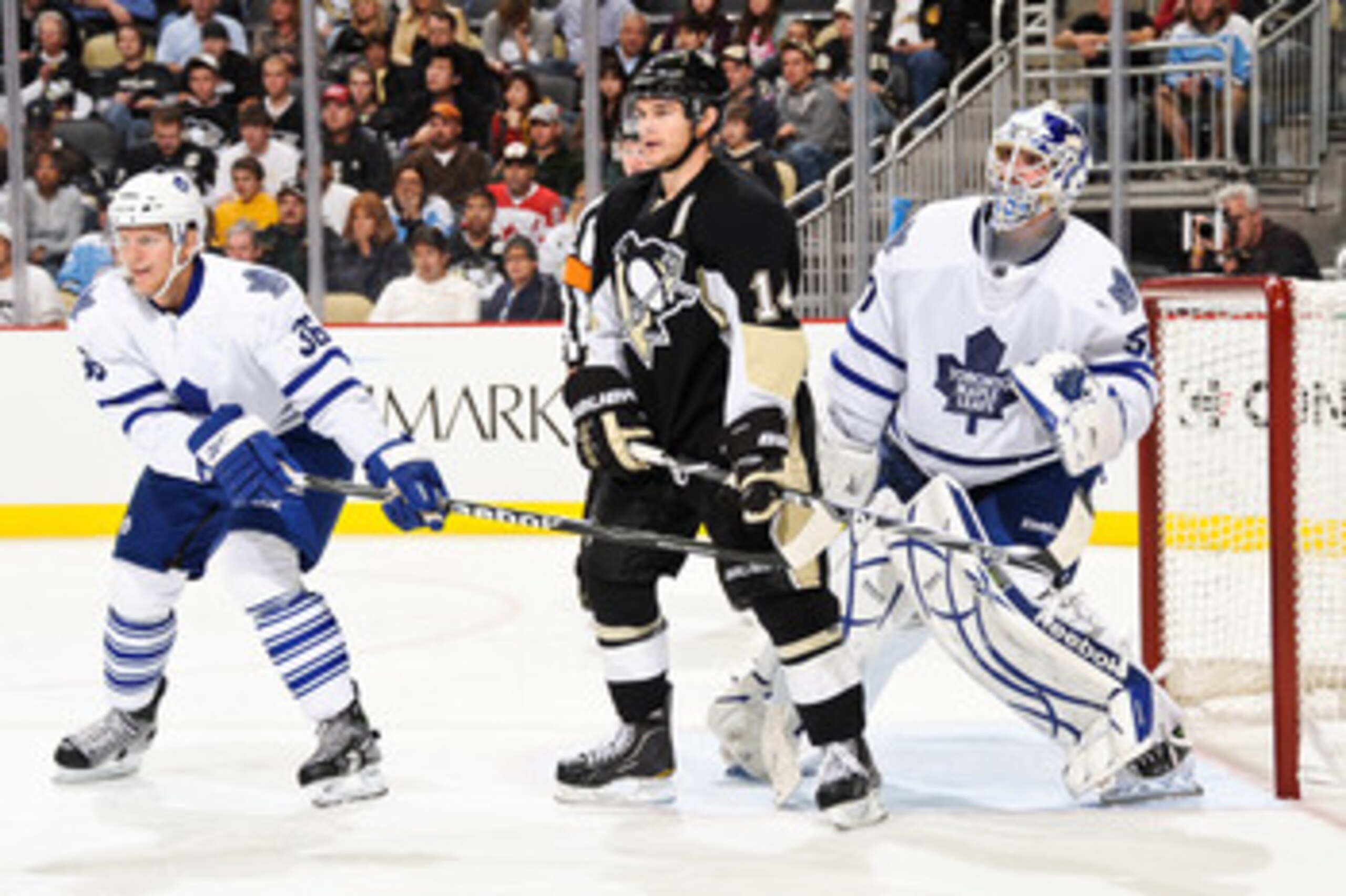 PITTSBURGH - OCTOBER 13:  Carl Gunnarsson #36 of the Toronto Maple Leafs and Chris Kunitz #14 of the Pittsburgh Penguins set up in front of goaltender Jonas Gustavsson #50 of the Toronto Maple Leafs during a Pittsburgh power play on October 13, 2010 at Co