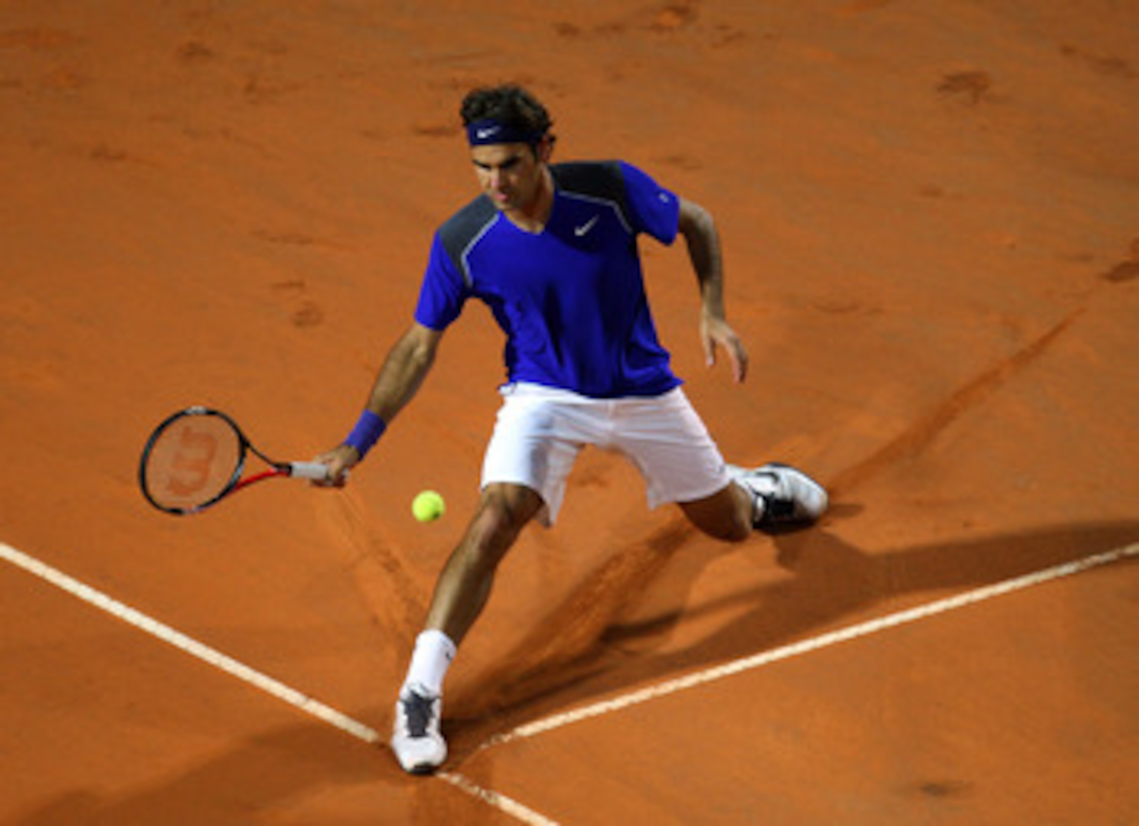 ROME, ITALY - MAY 11:  Roger Federer of Switzerland stretches for the ball during his second round match against Jo-Wilfried Tsonga of France during day four of the Internazionali BNL d'Italia at the Foro Italico Tennis Centreon May 11, 2011 in Rome, Ital