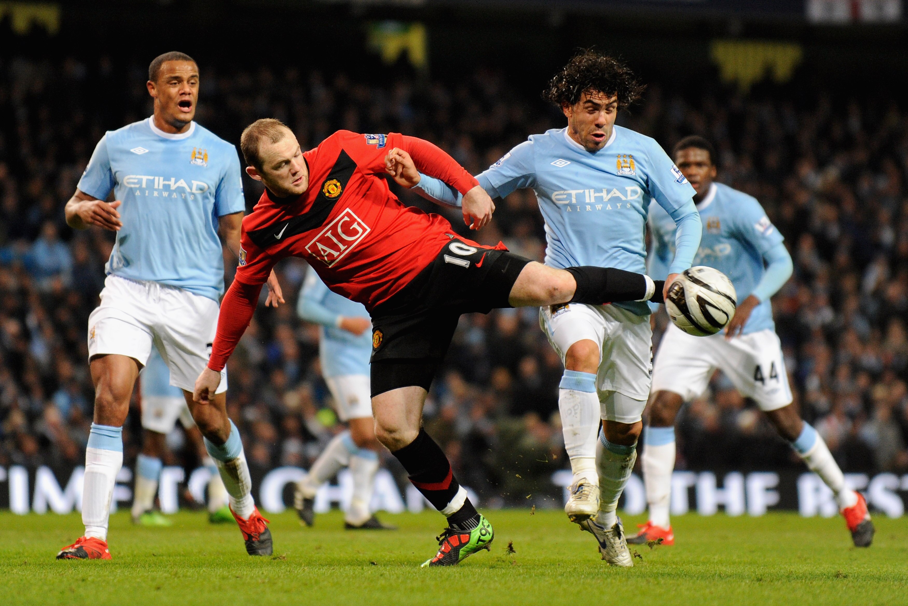 MANCHESTER, UNITED KINGDOM - JANUARY 19:   Wayne Rooney of Manchester United battles for the ball with Carlos Tevez of Manchester City during the Carling Cup Semi Final match between Manchester City and Manchester United at the City of Manchester Stadium