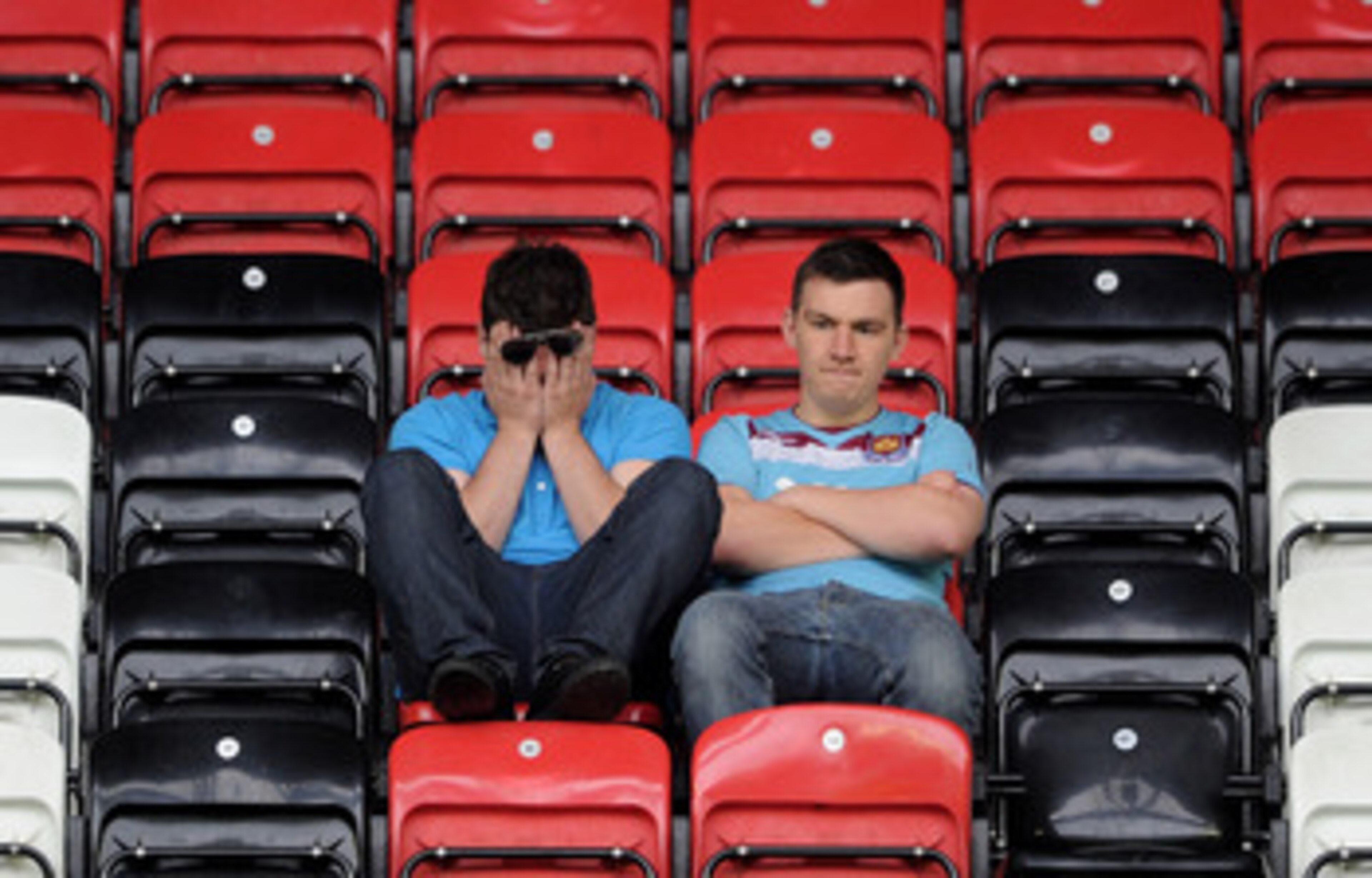 WIGAN, ENGLAND - MAY 15:  West Ham United fans look dejected following their relegation at the end of the Barclays Premier League match between Wigan Athletic and West Ham United at the DW Stadium on May 15, 2011 in Wigan, England.  (Photo by Chris Brunsk