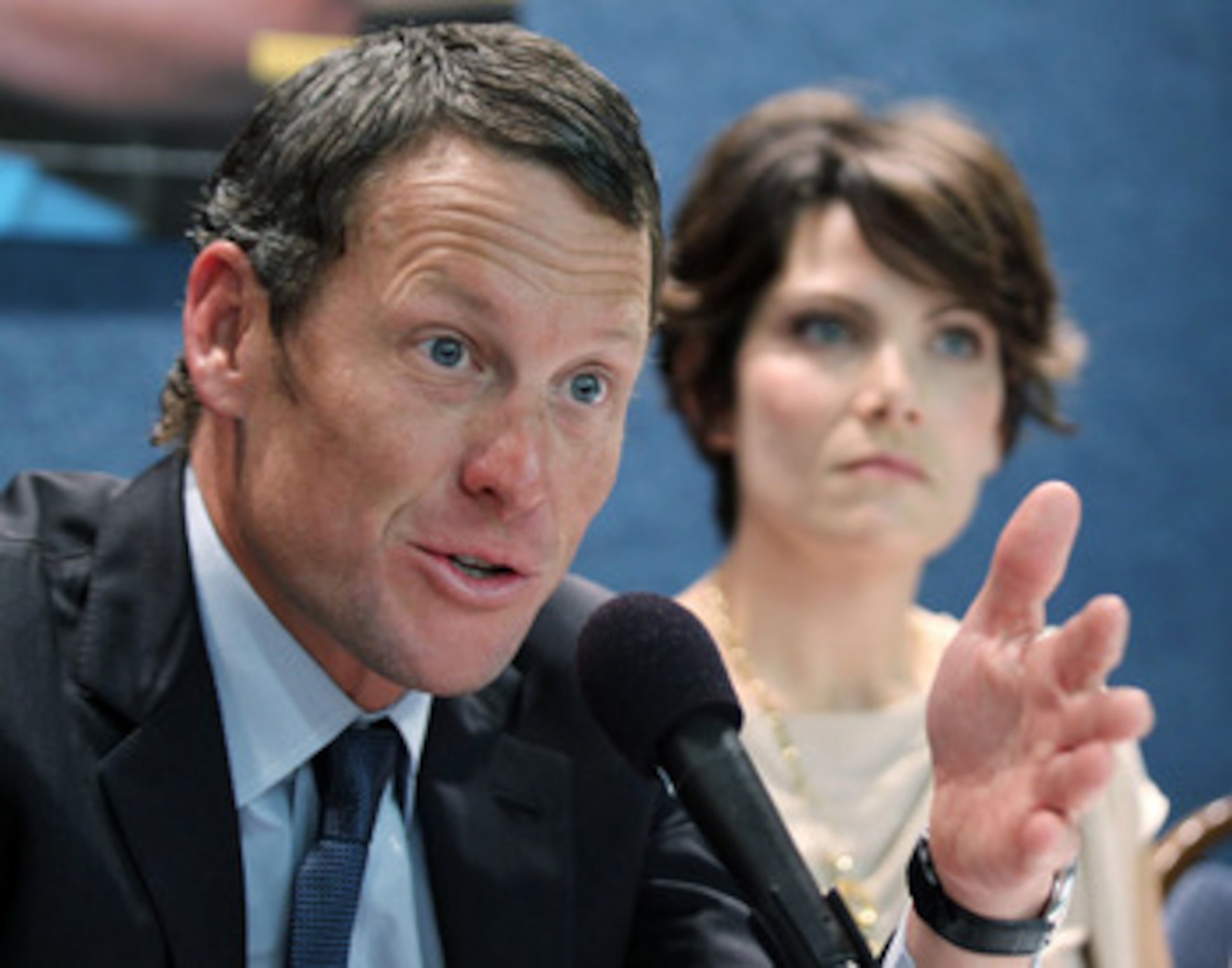 WASHINGTON, DC - MARCH 24:  LIVESTRONG Founder and Chairman and seven-time Tour de France champion Lance Armstrong (L) speaks as cancer survivor Tracy Elliman (R) of Kennett Square, Pennsylvania, listens during a news conference at the National Press Club